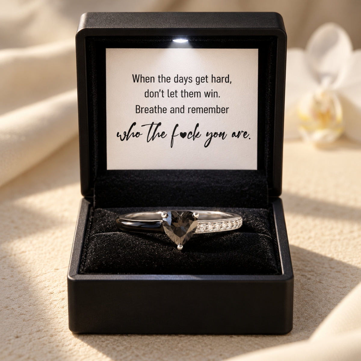 Silver heart ring with a black centre and black enamel accents, in an LED gift box with the included encouragement card.