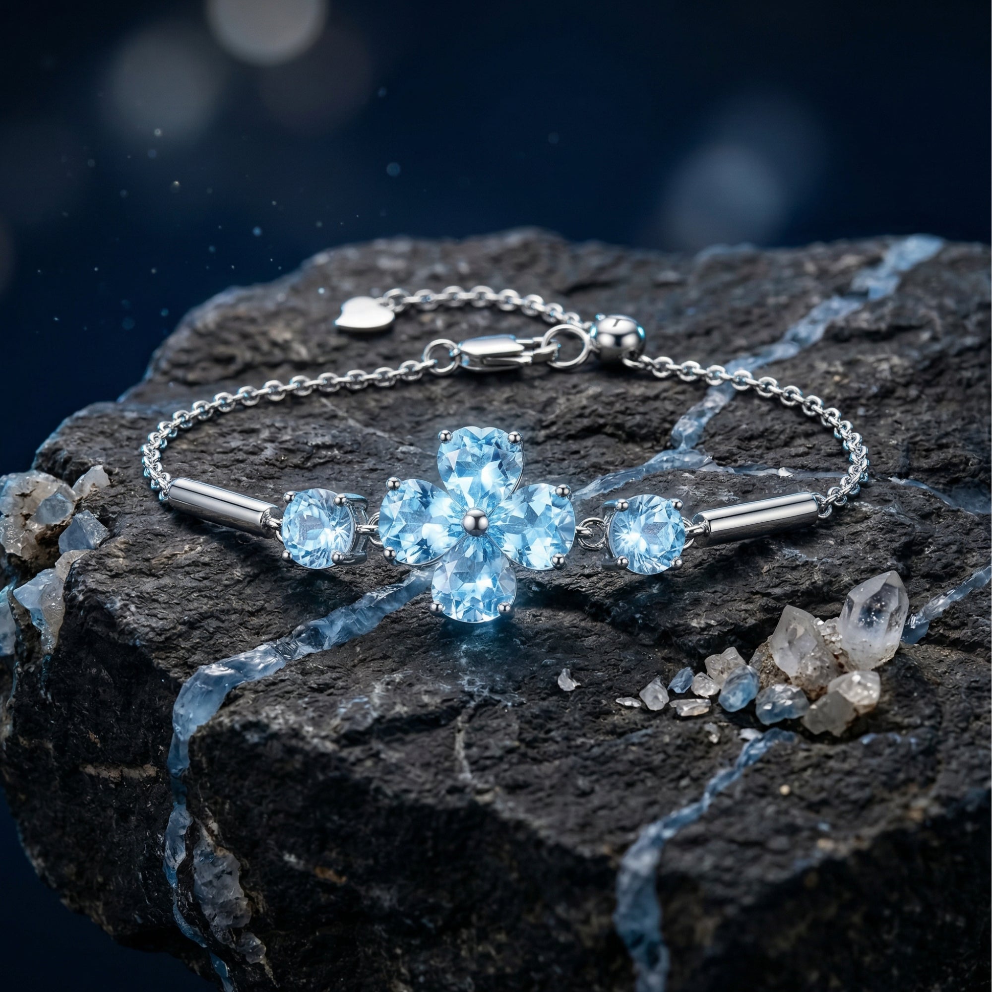 Silver Azurette clover bracelet with heart and round cut Swiss blue topaz stones on a dark textured rock.
