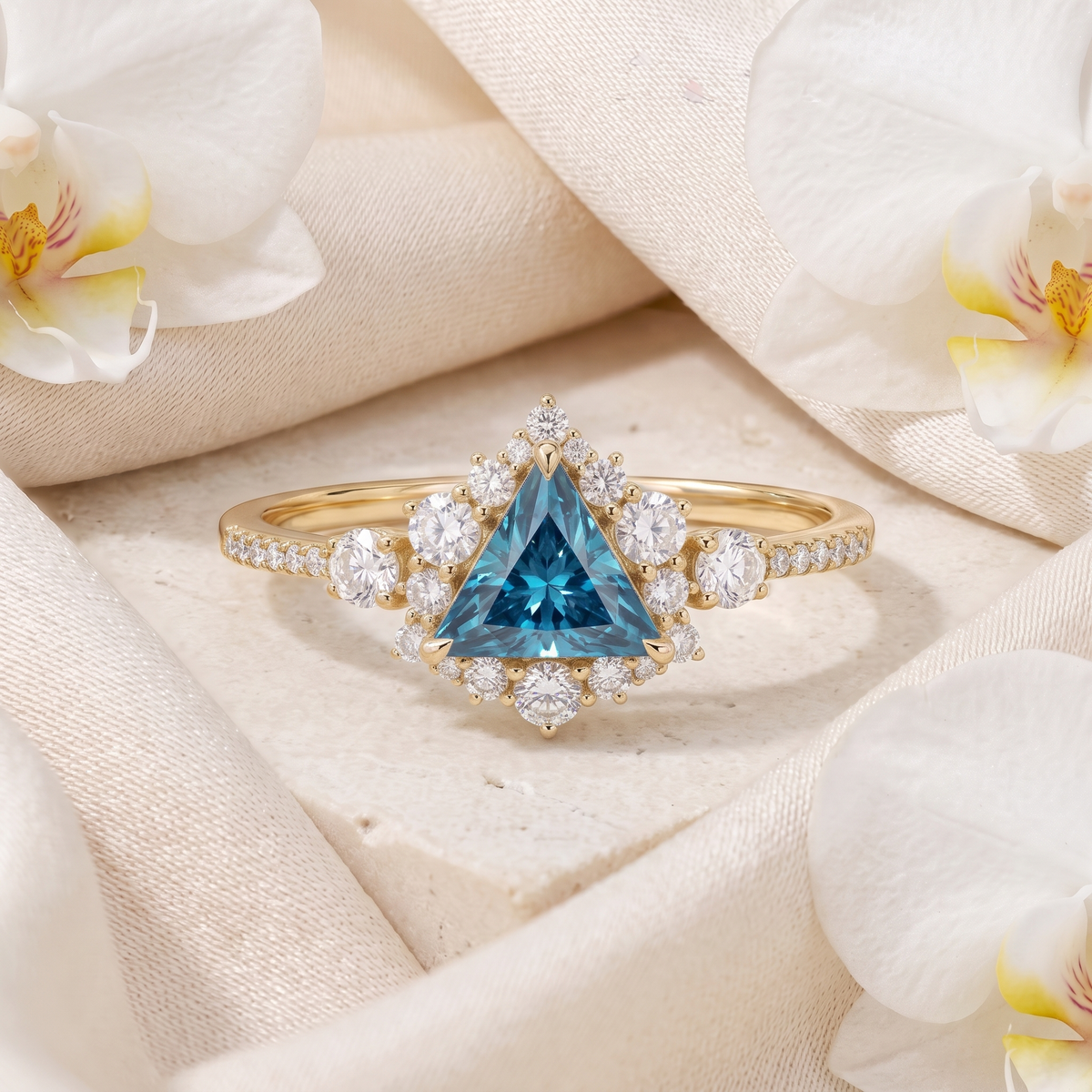 Yellow gold triangle cut blue gemstone ring with diamond halo and pavé band.