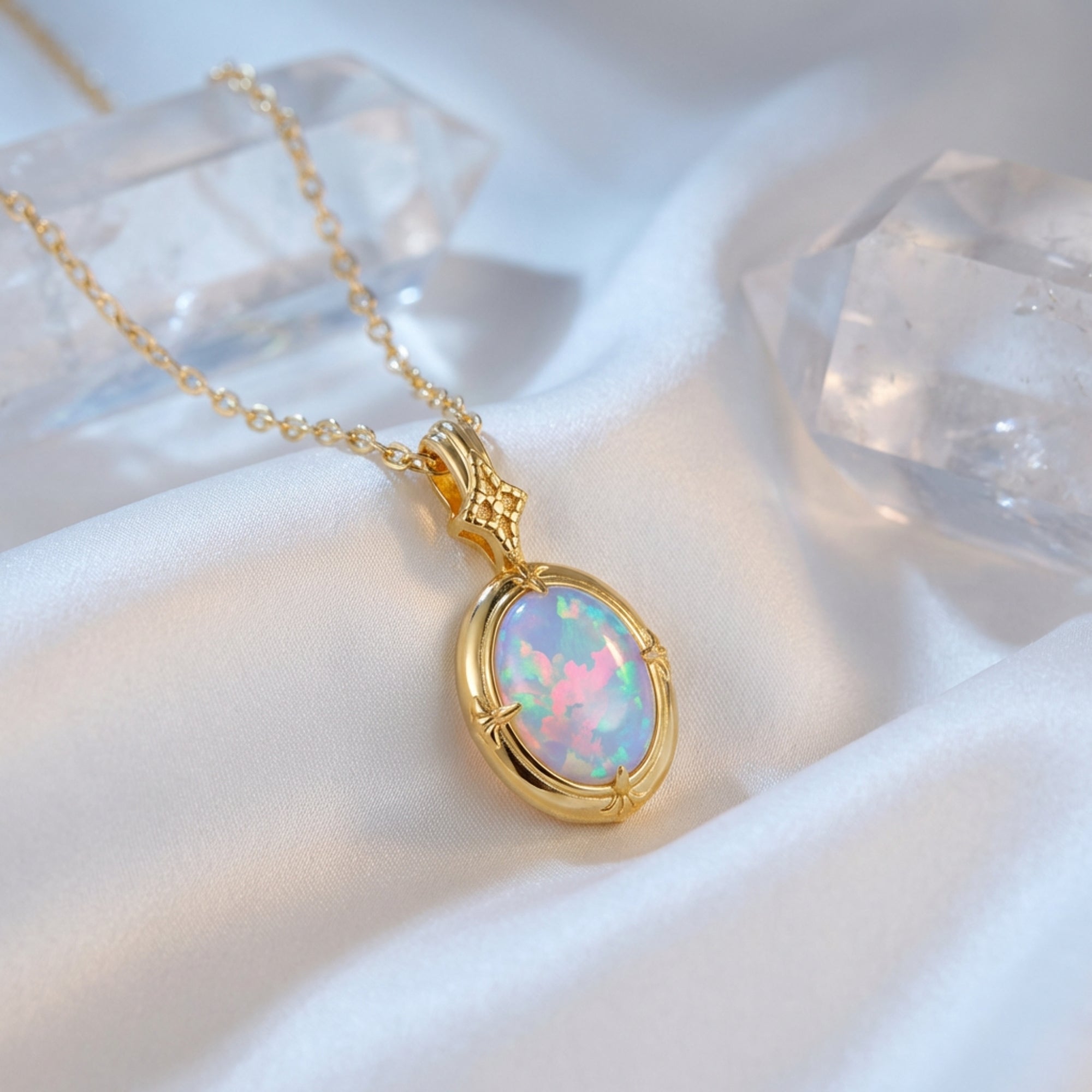 Gold-tone oval white opal pendant necklace on white silk with quartz crystal points.