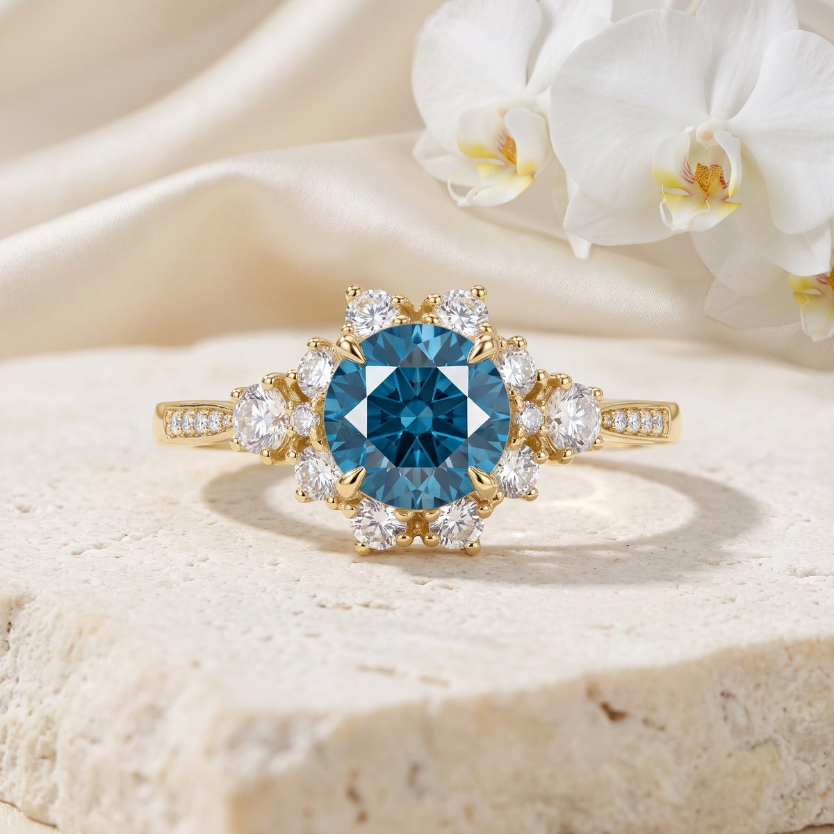 Yellow gold halo engagement ring featuring a round blue center moissanite stone surrounded by a diamond cluster.