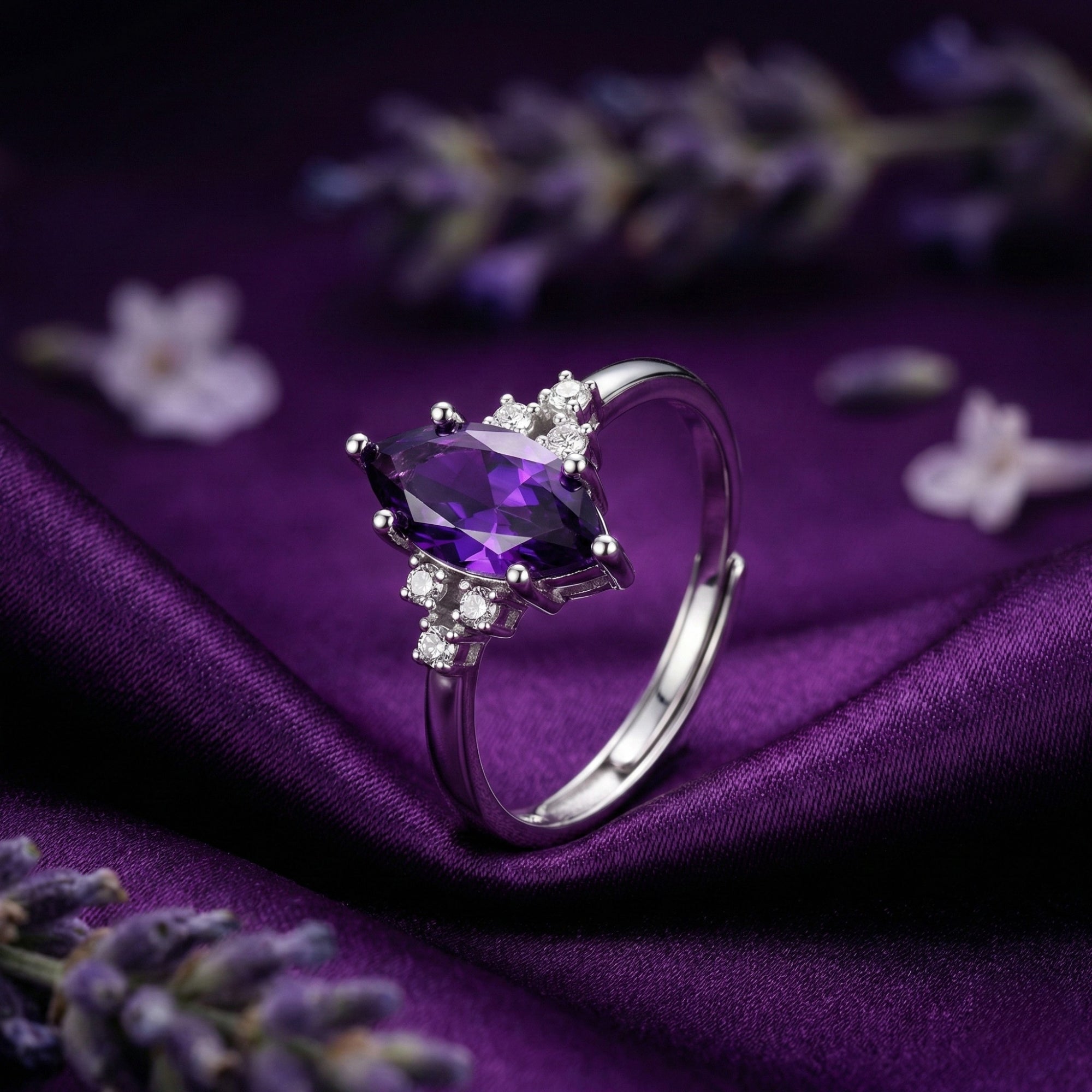 Marquesa cut amethyst ring in sterling silver, angled front view on purple silk with lavender sprigs.