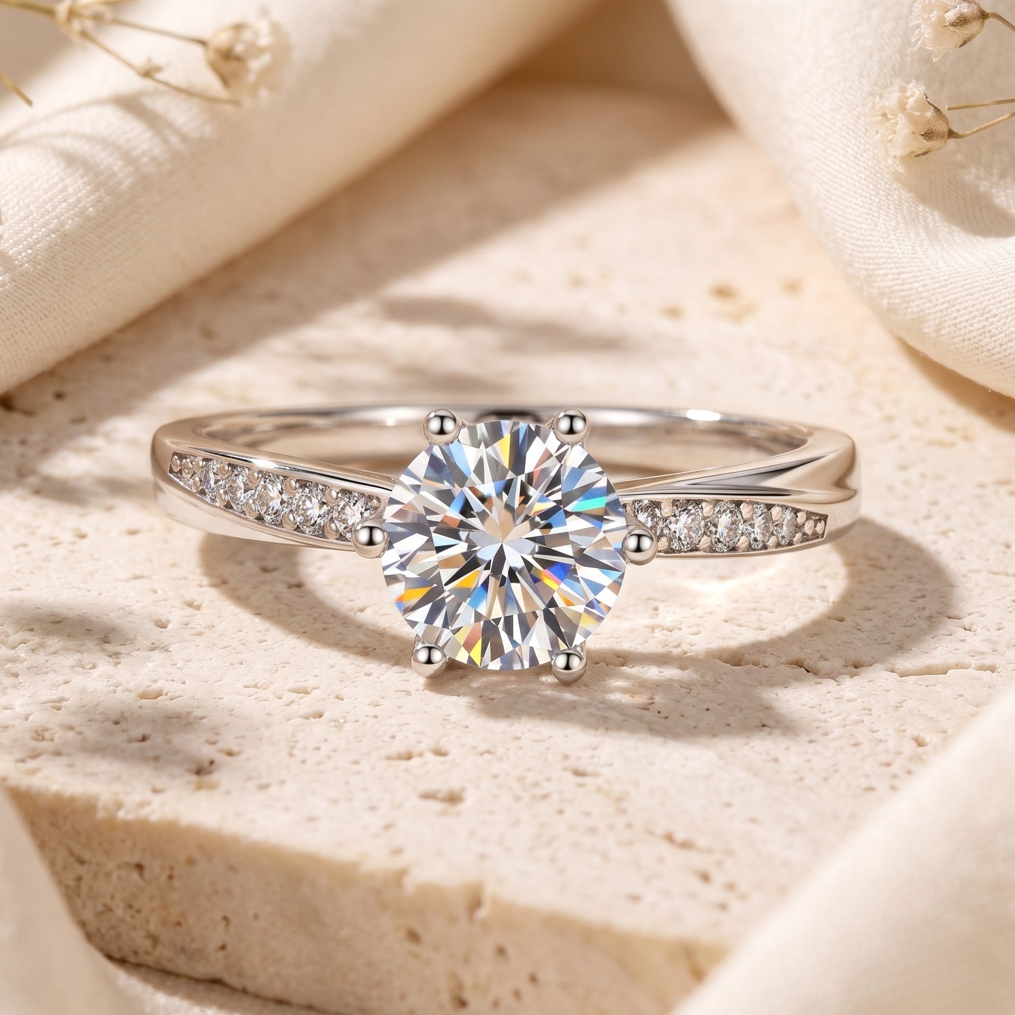 Silver solitaire ring with round cubic zirconia on a stone surface.