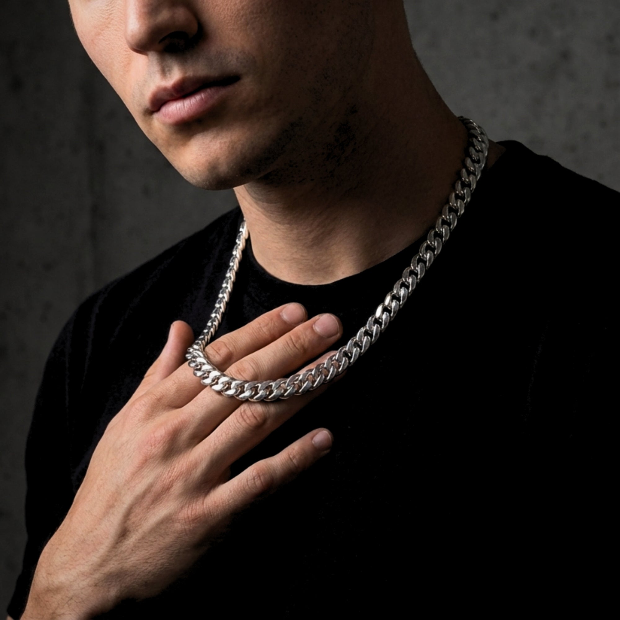 Man wearing a 10mm silver stainless steel Cuban link chain over a black t-shirt.