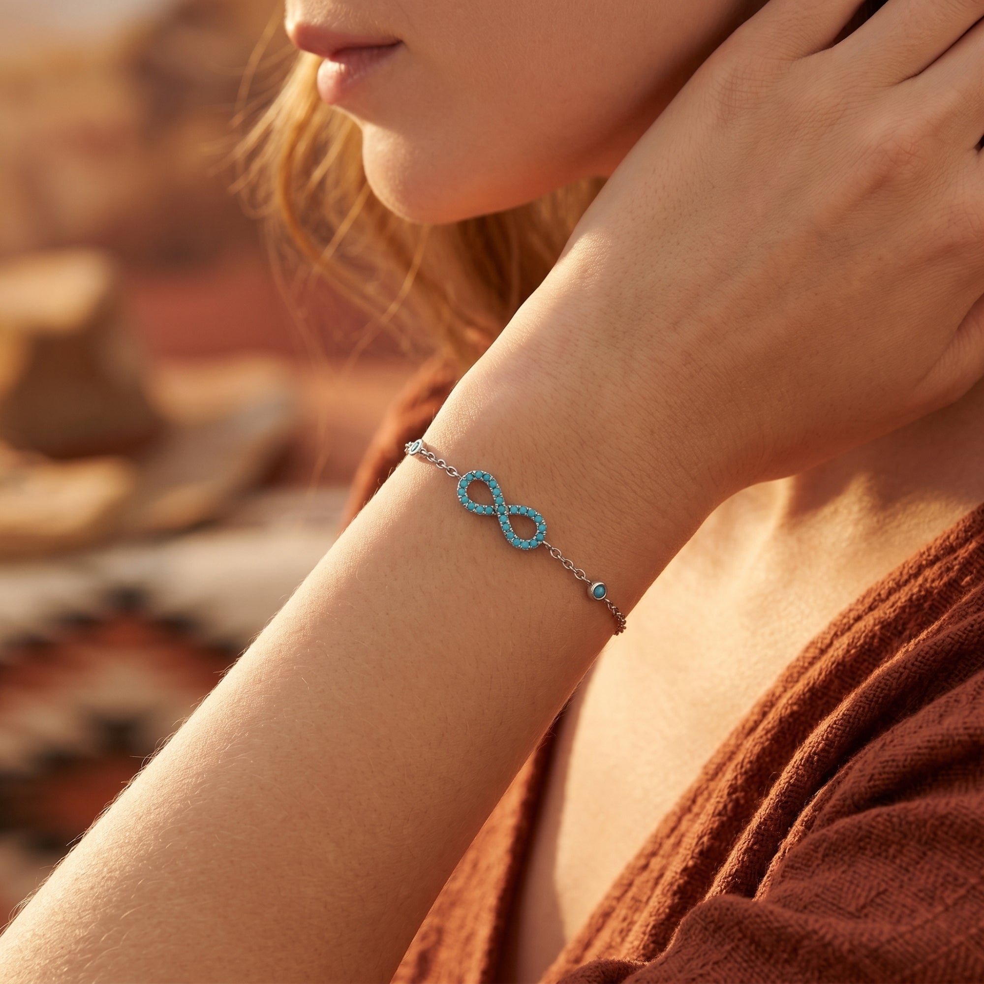 Turquoise infinity bracelet in silver worn on a woman's wrist for a Southwestern look.