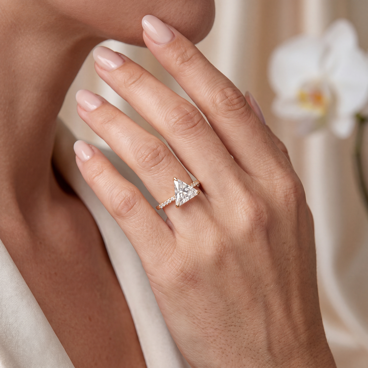 A woman wearing the yellow gold triangle-cut moissanite ring on her hand.