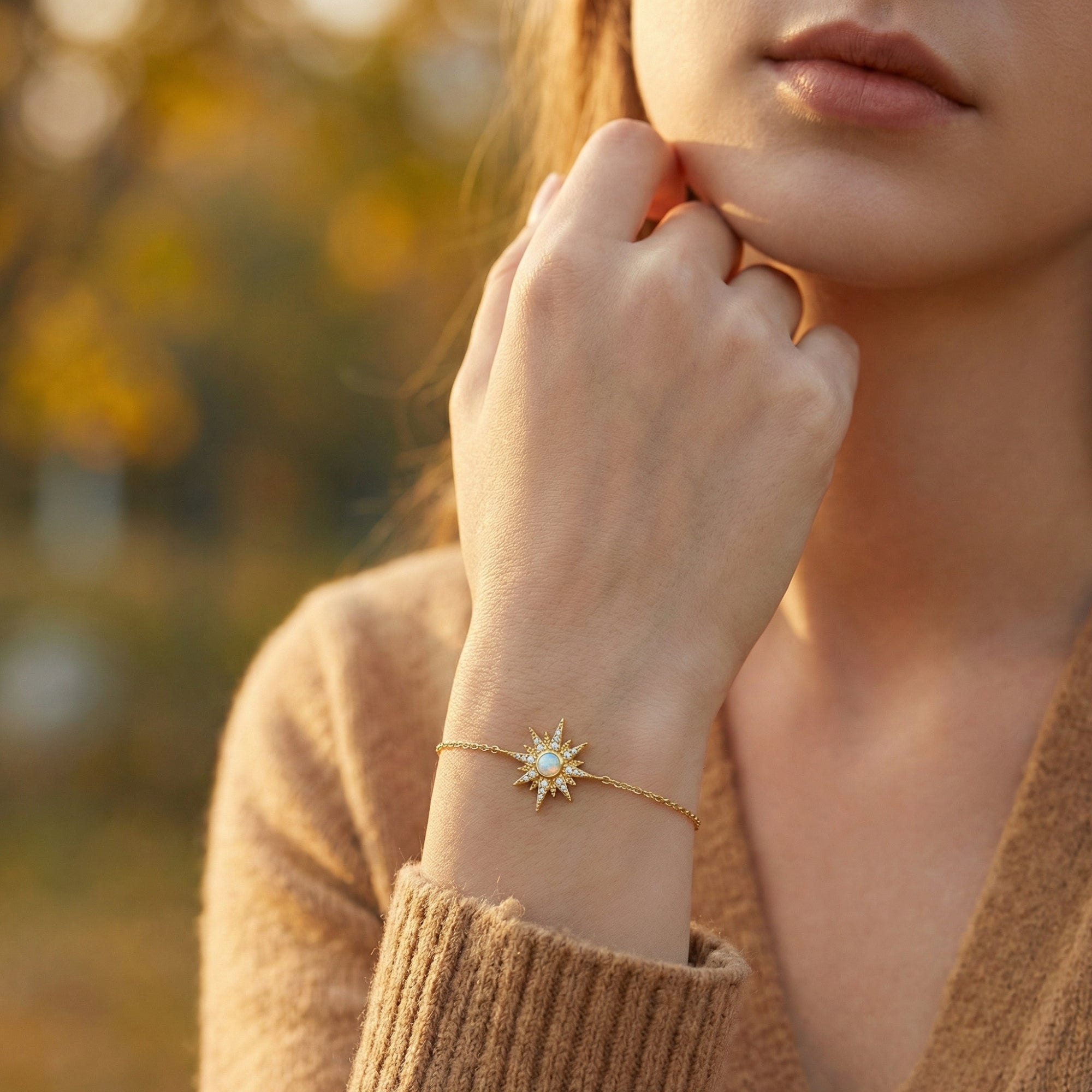 Gold-tone sterling silver Elowen starburst opal bracelet with a round-cut stone worn on a woman's wrist.