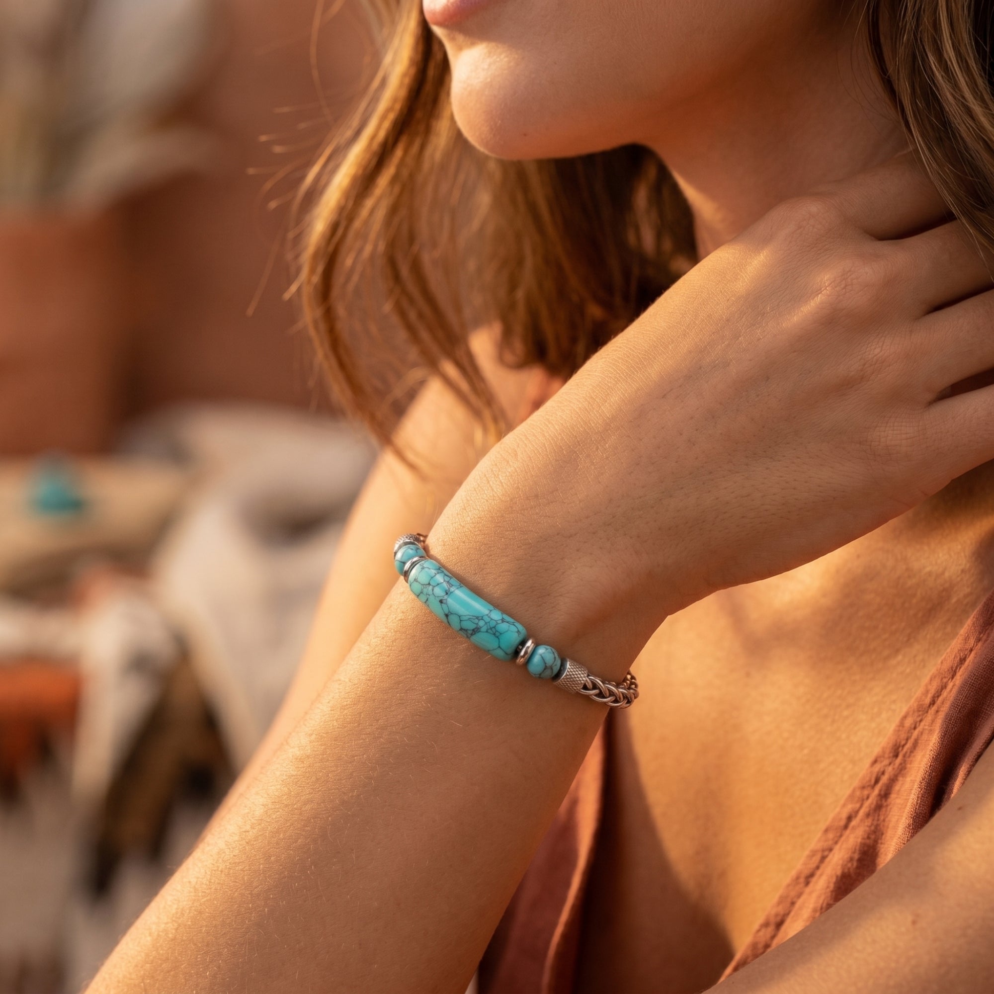 Model wearing the silver stainless steel Chimayo turquoise bracelet with a blue-green focal bar on her wrist.