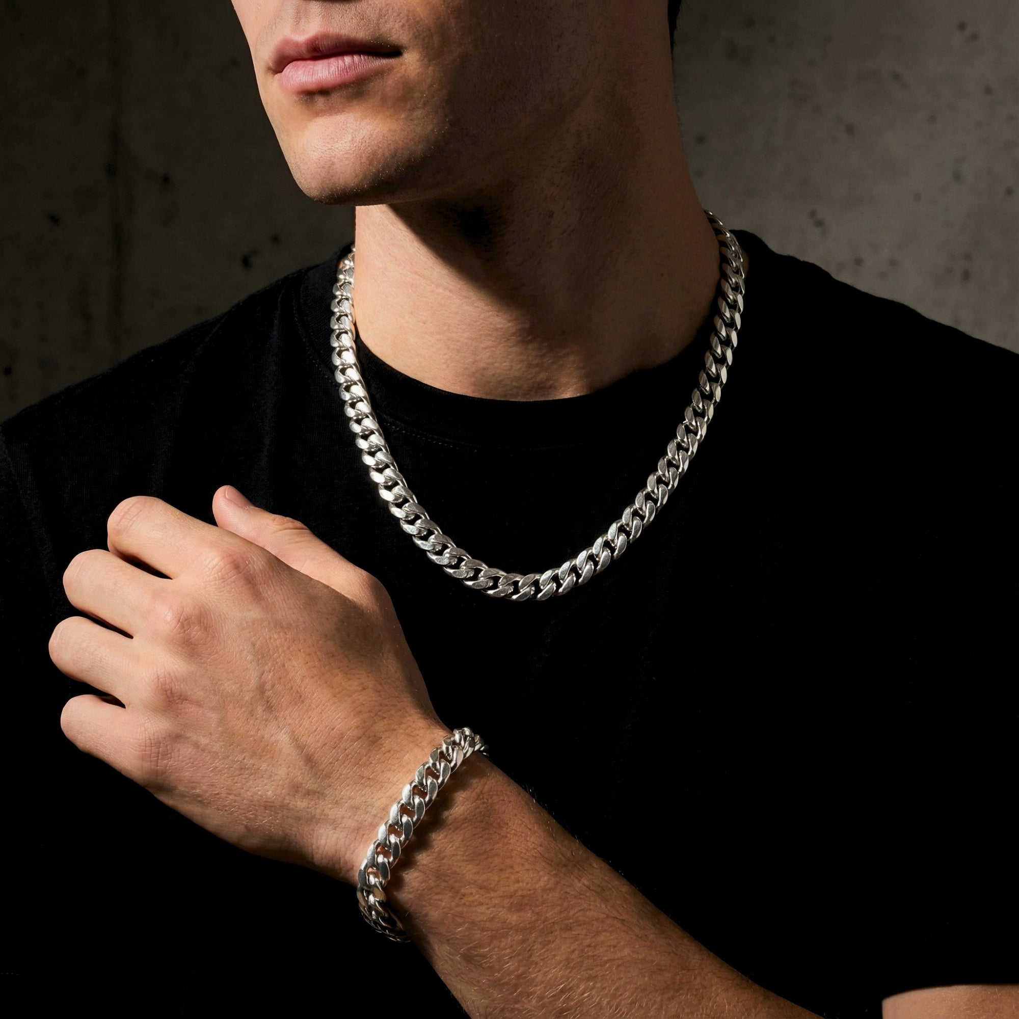 Model wearing the 10mm polished silver stainless steel Cuban link chain and matching bracelet with a black t-shirt.