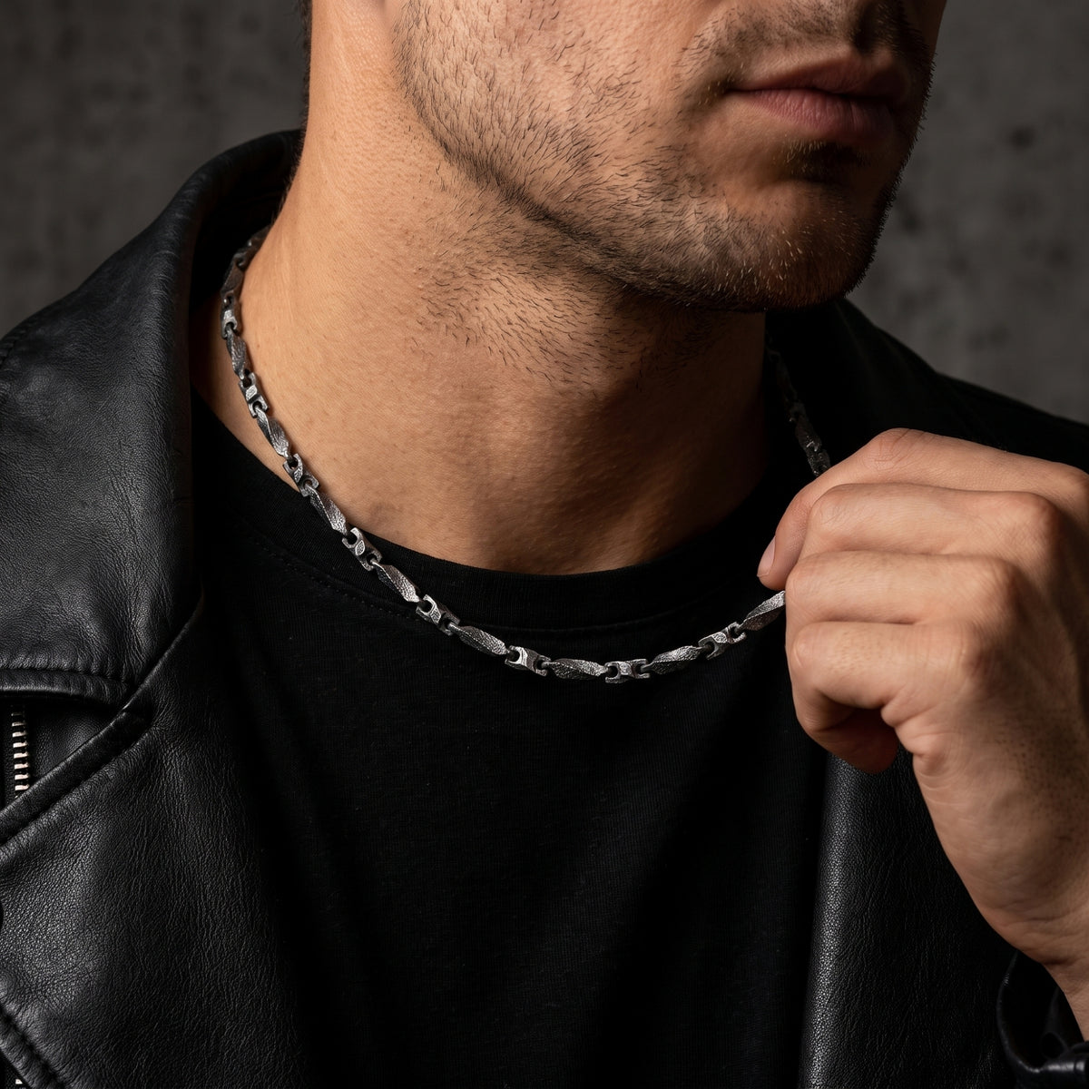 Man wearing the textured silver bar link chain with a black T-shirt and leather jacket.
