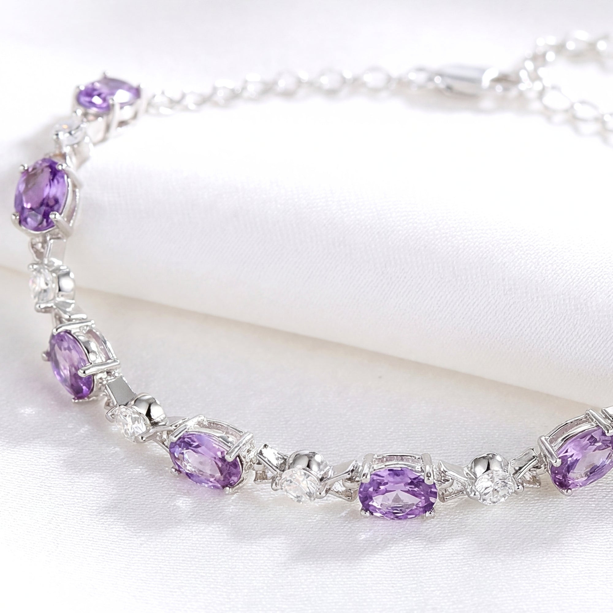 Macro view of the Valeriane sterling silver bracelet showing oval-cut simulated amethyst and round clear stones.