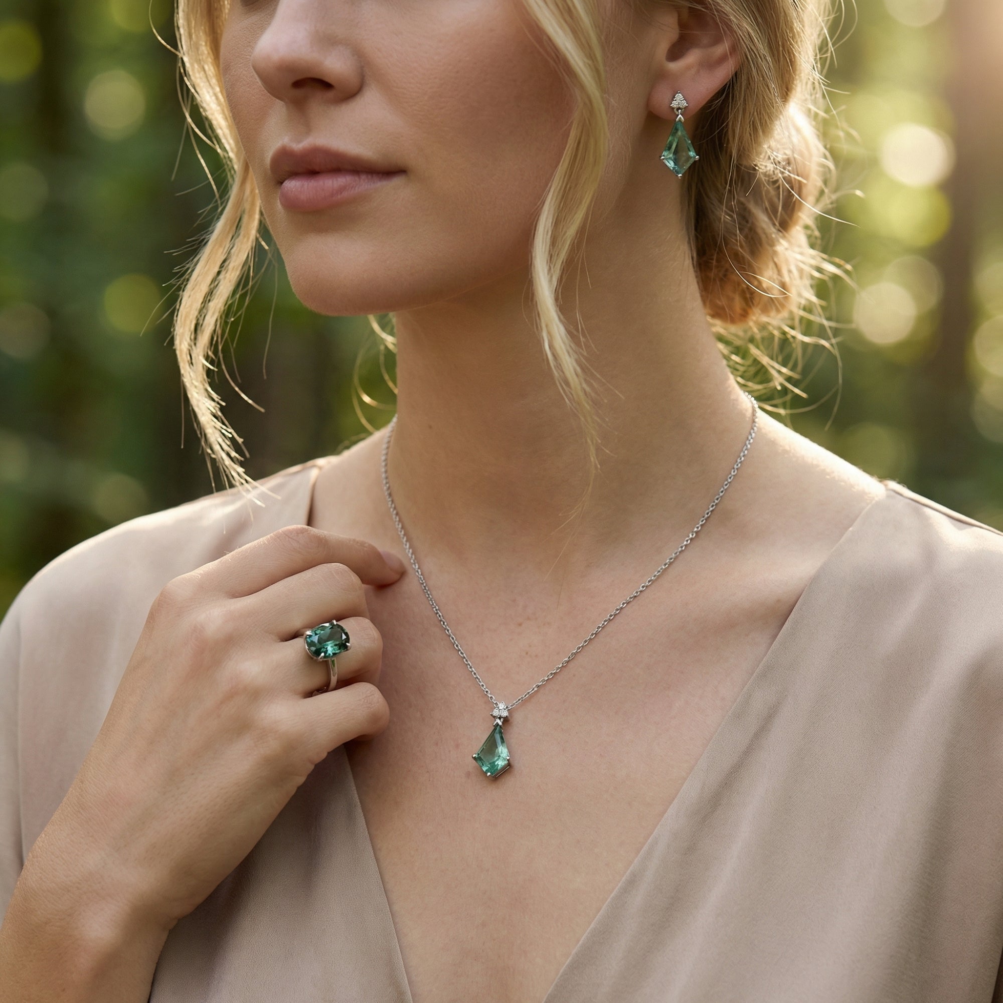 Model wearing the Aurora jewelry set featuring a green moissanite ring and moss agate necklace and earrings.
