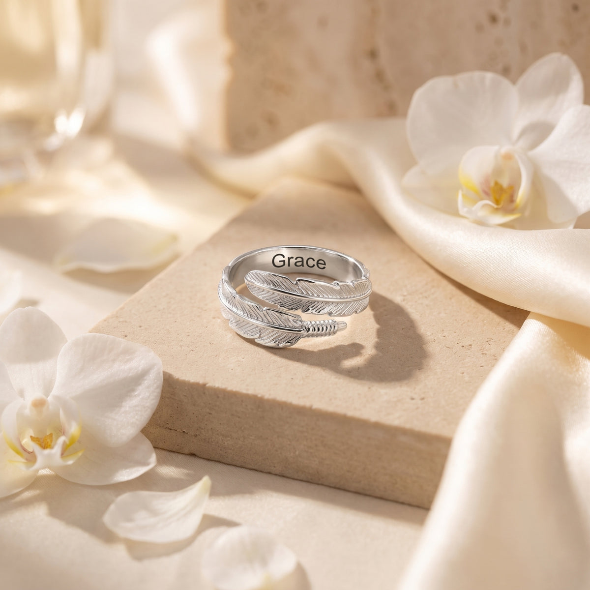 Silver feather wrap ring showing example Grace engraving inside the band
