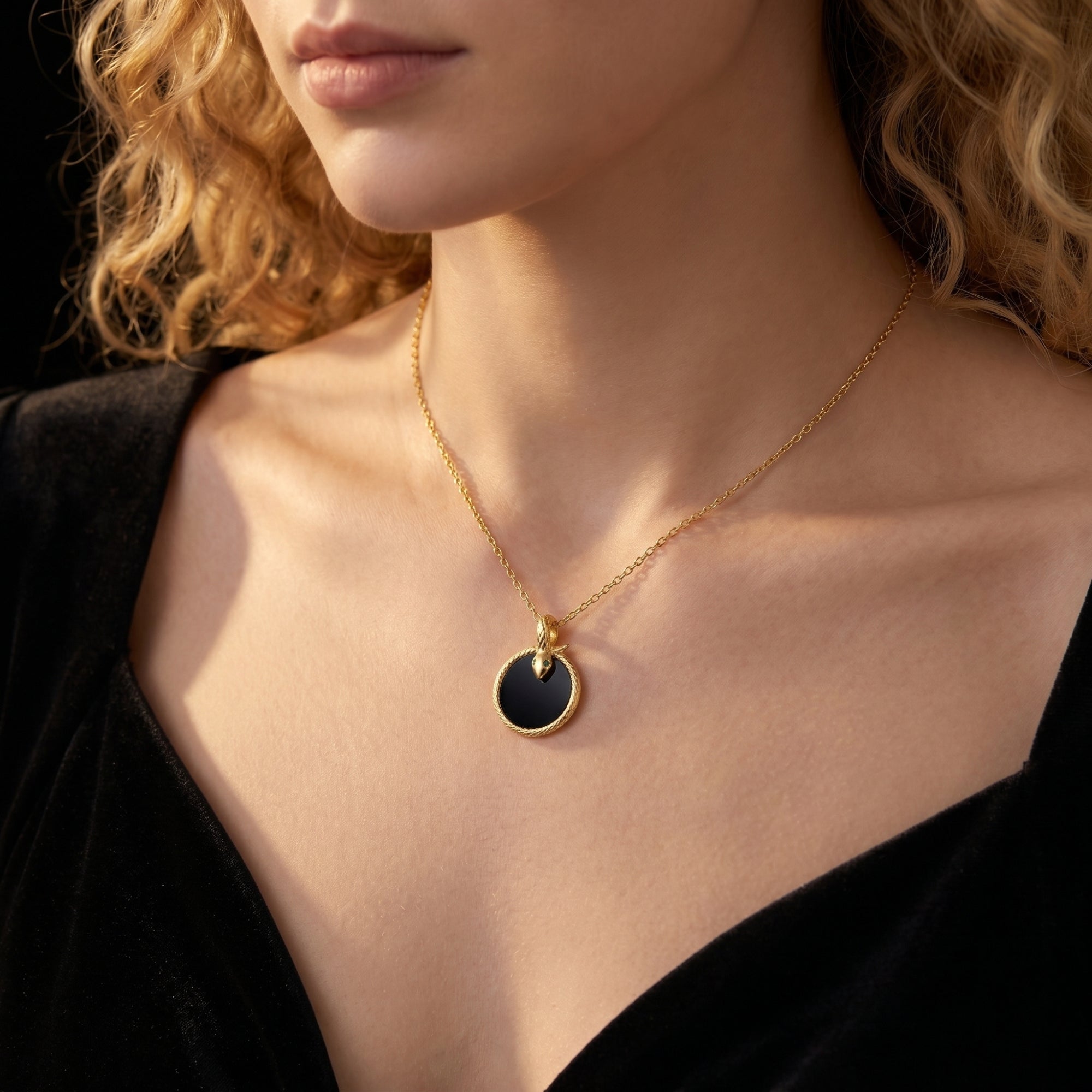 Model wearing the gold Polaris snake necklace with a round black onyx pendant.