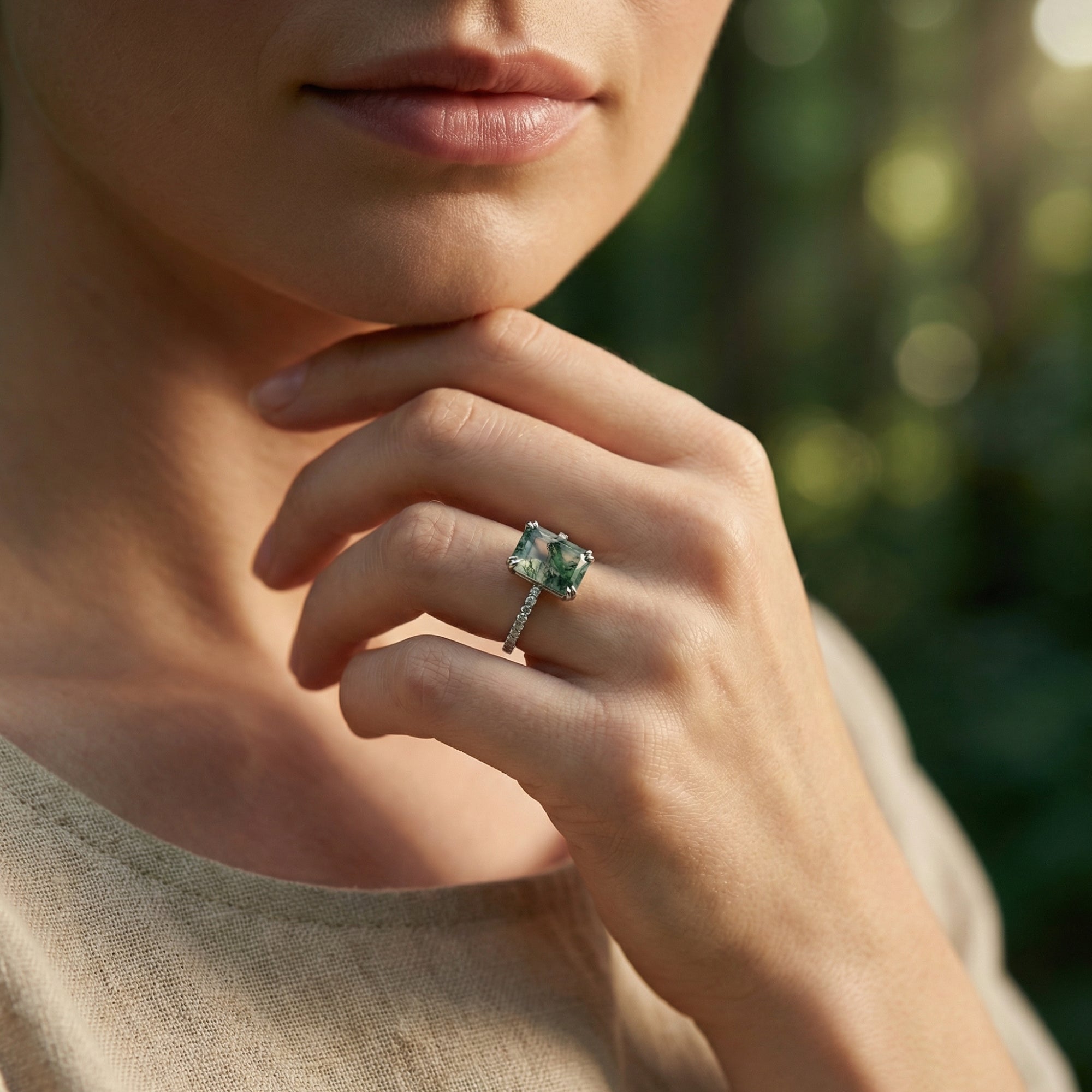 Model wearing a rectangular moss agate ring in S925 sterling silver with a pavé diamond band in a natural setting.