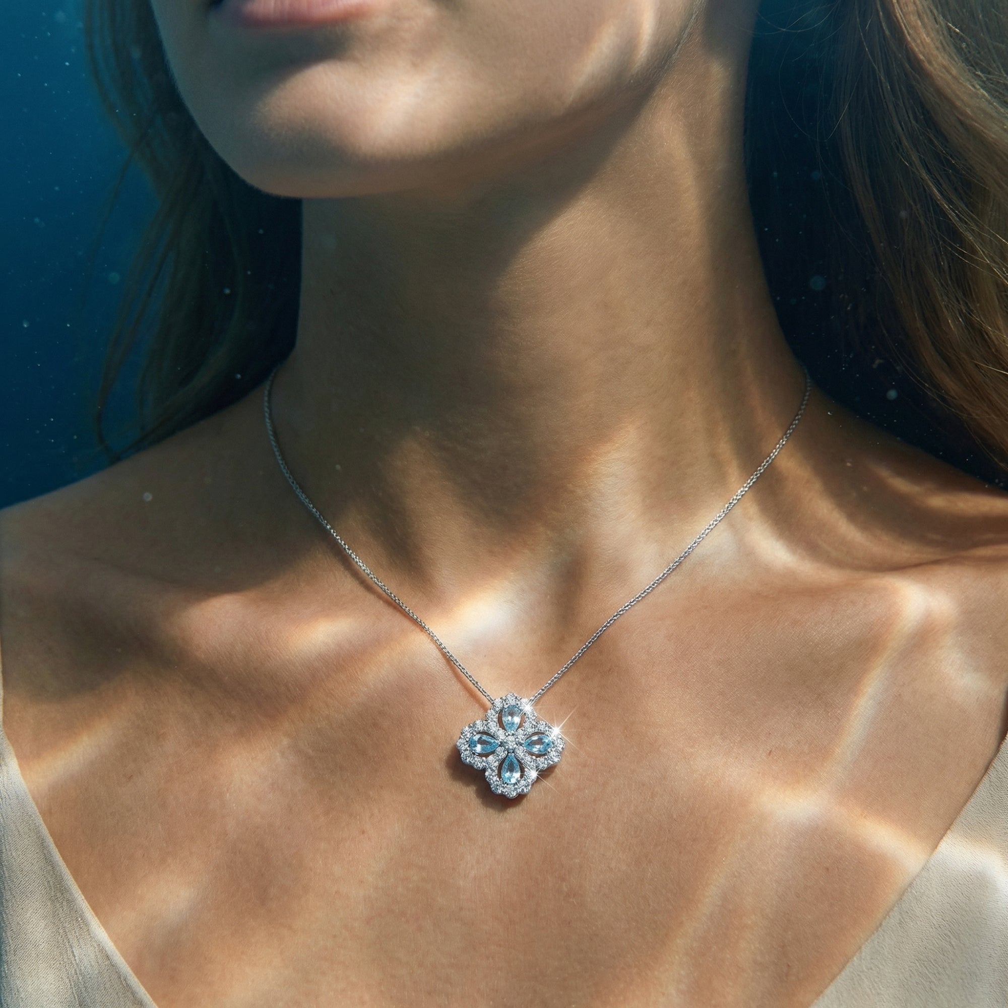 Model wearing the Aelinor pear cut aquamarine floral pendant in sterling silver on a delicate chain.