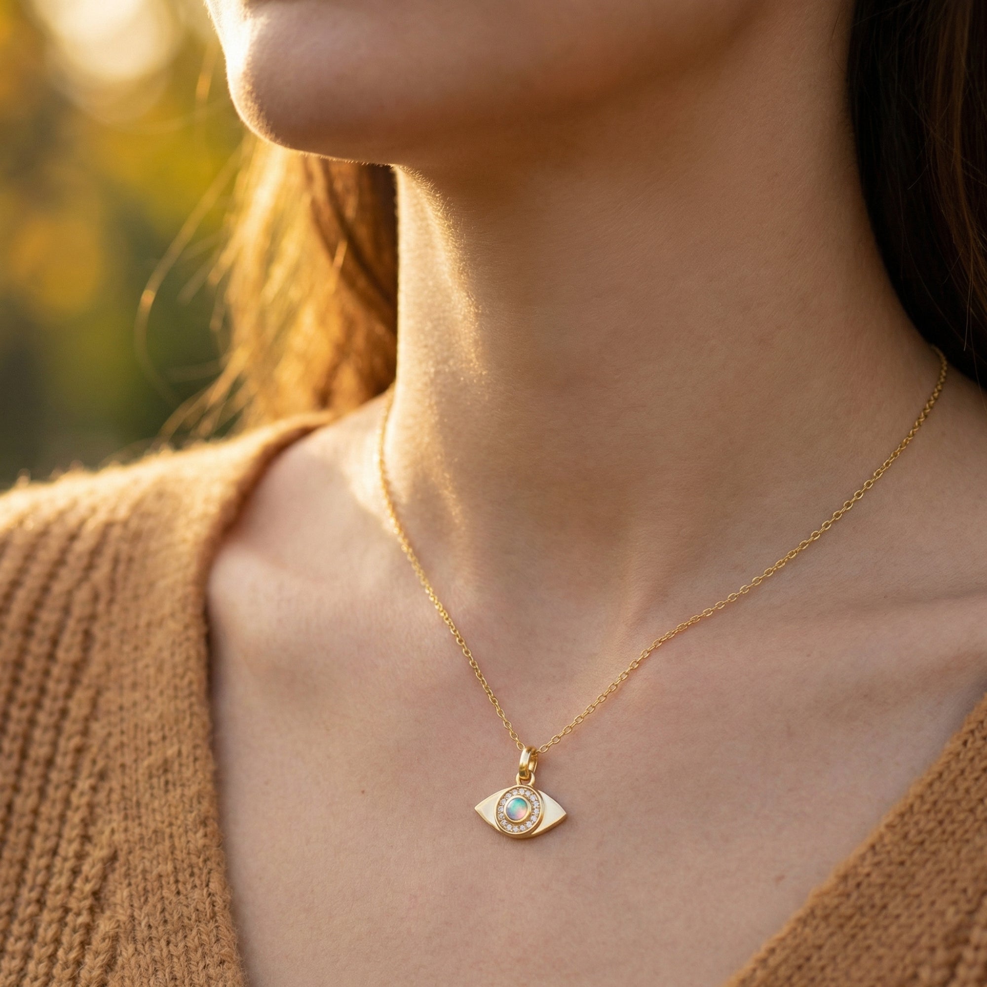 Woman wearing the gold evil eye pendant necklace with a round white opal stone in a lifestyle setting.