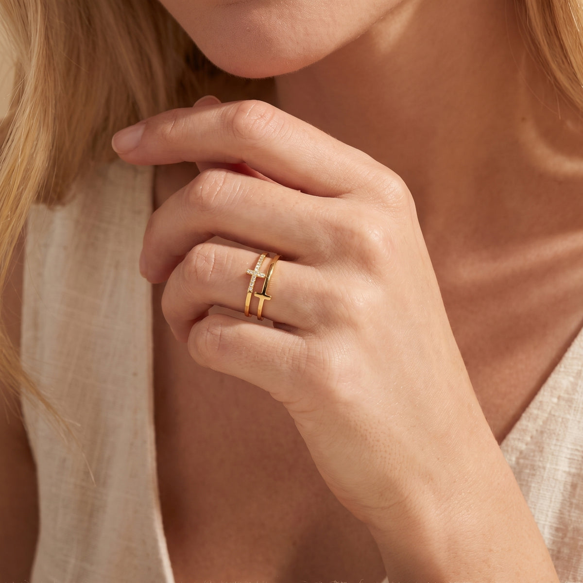 Close-up of a model wearing the gold dual-band cross ring near her chin.