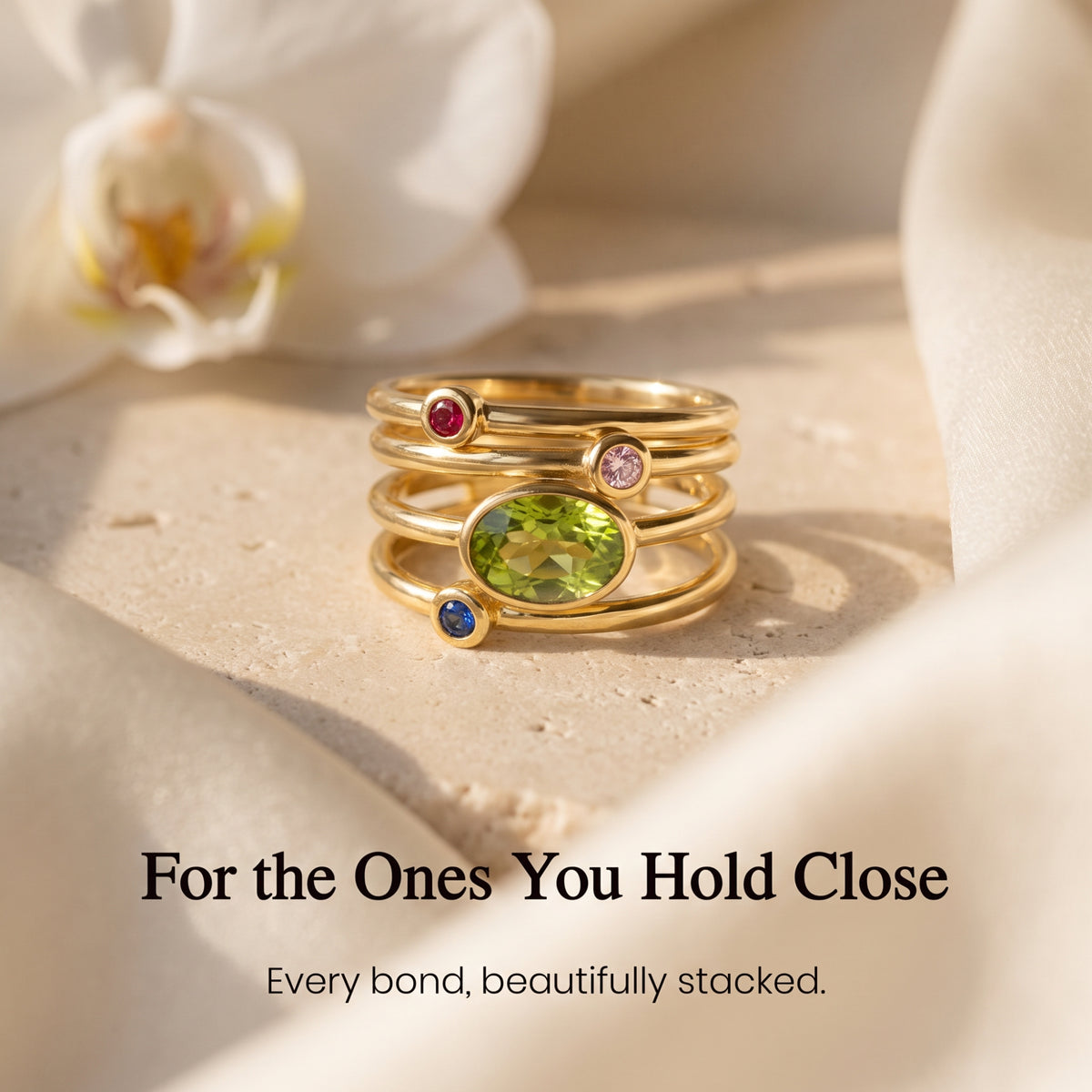 Gold-tone family ring stack with oval green centre and round child stones