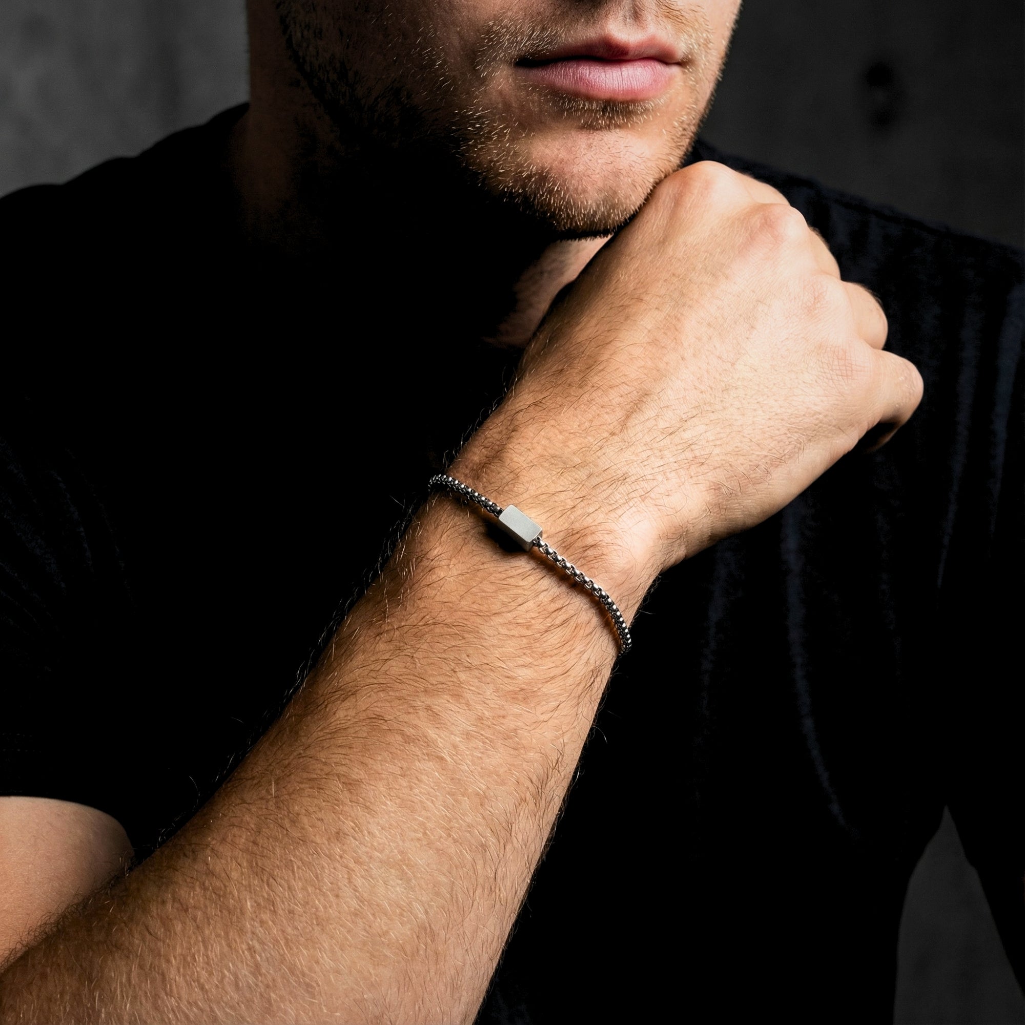Men's 5mm silver stainless steel link ID bracelet worn on a wrist, styled with a black t-shirt.