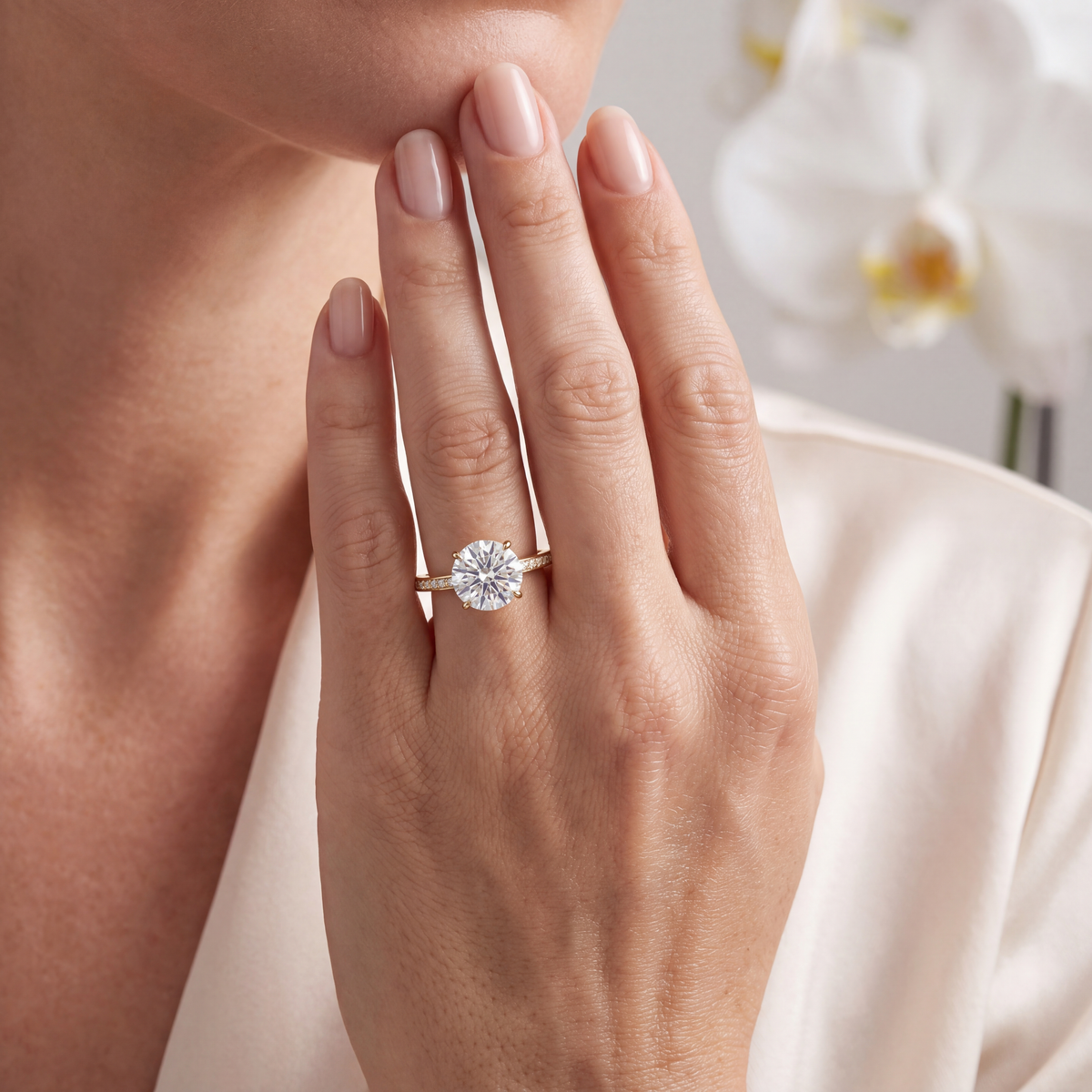 Yellow gold round moissanite engagement ring worn on a hand.