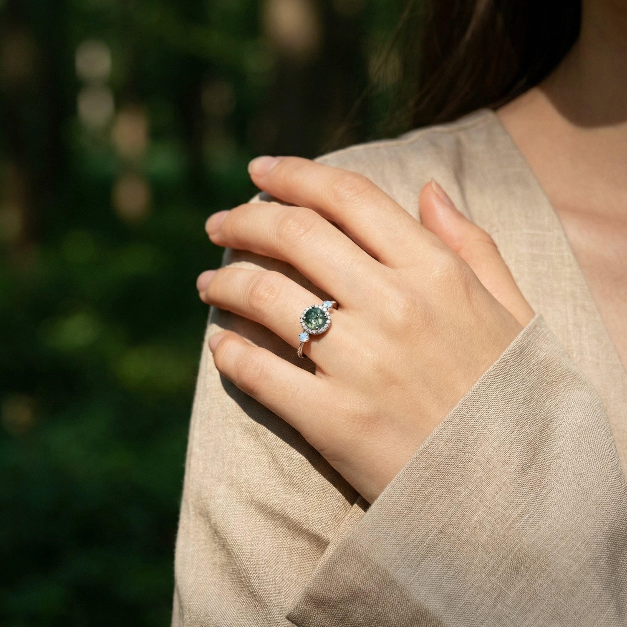 Model wearing the round cut moss agate and opal halo ring in S925 sterling silver on her finger.