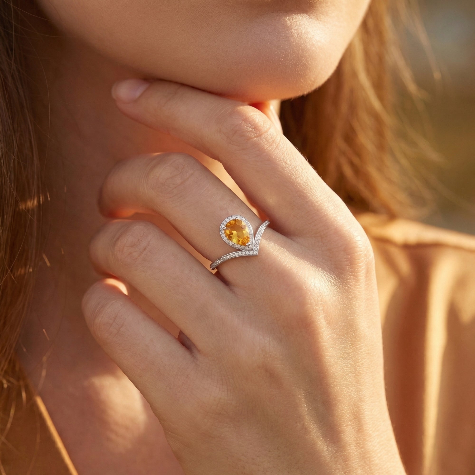 Woman wearing the Zinnia pear natural citrine sterling silver ring on her finger.