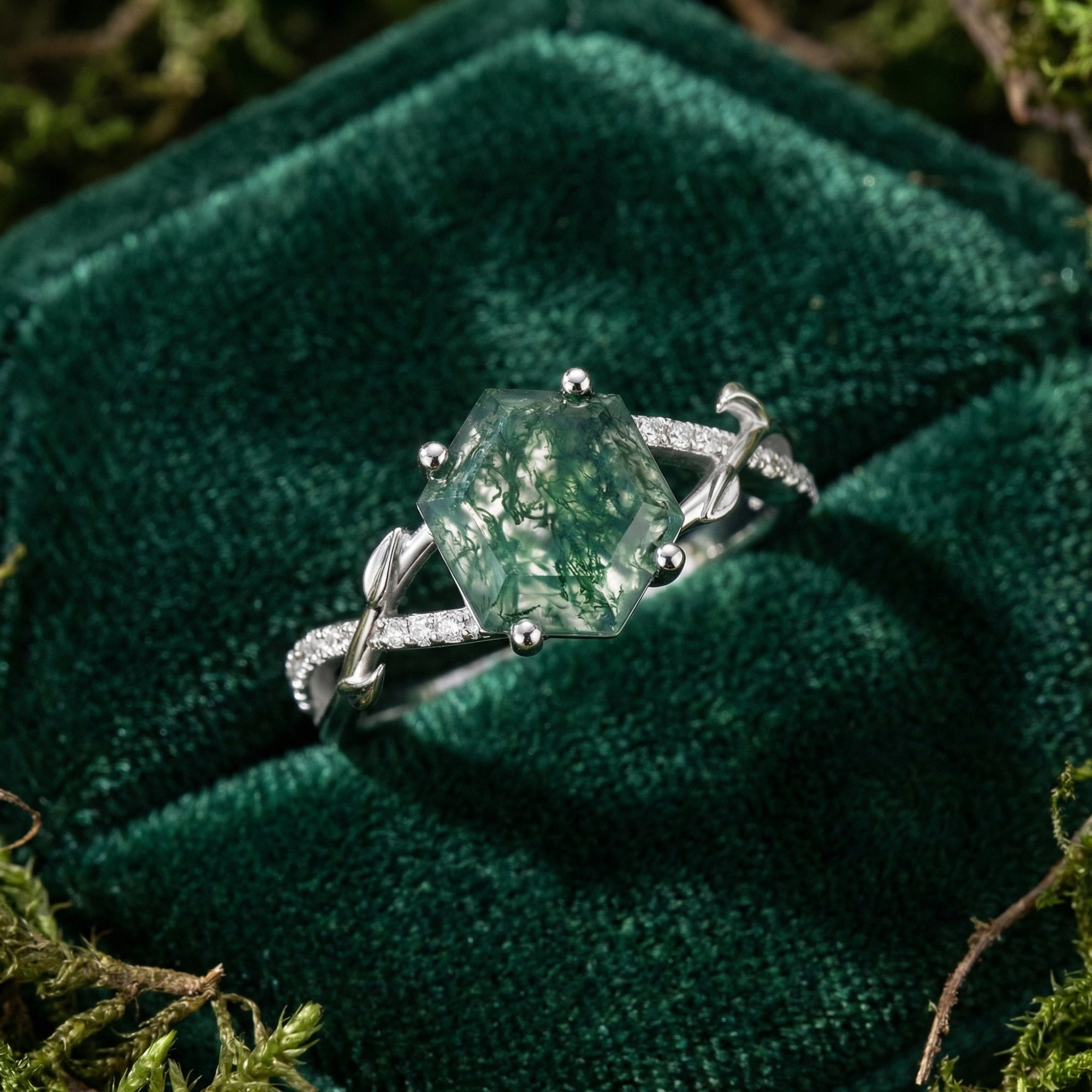 Macro shot of the hexagonal natural moss agate ring with diamond vine details in a green velvet box.