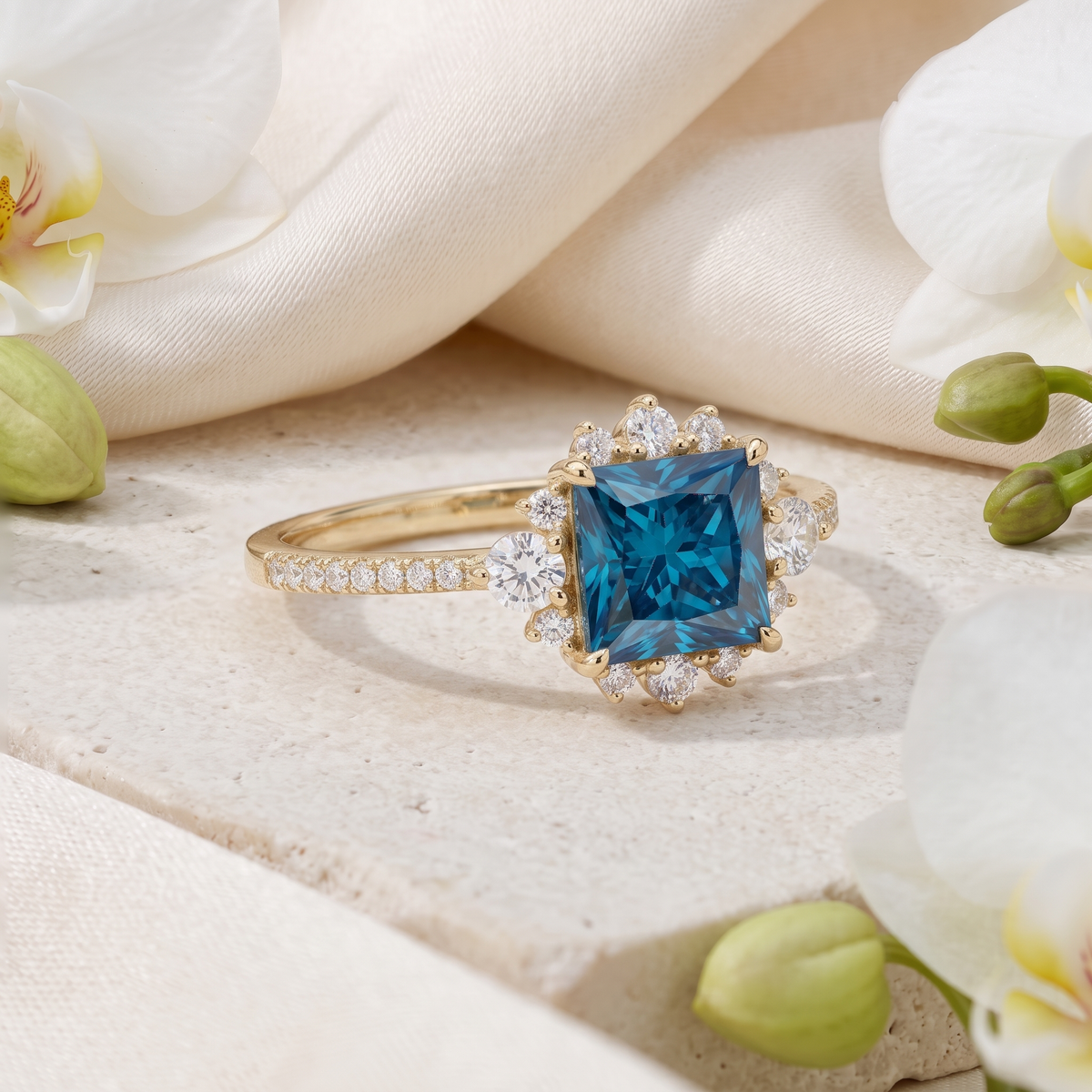 Angled view of princess cut blue moissanite ring with diamond halo in yellow gold