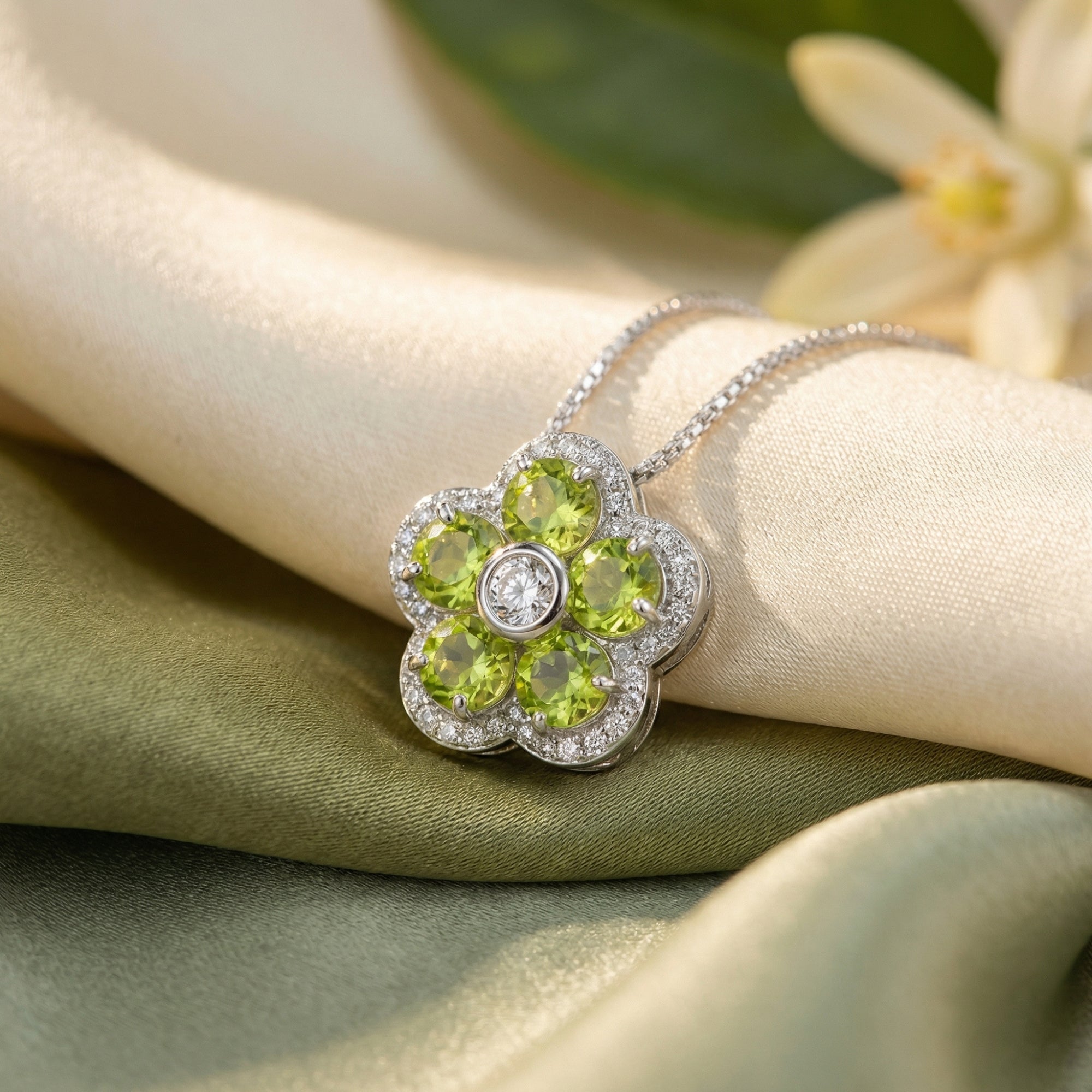 Close-up of the Florisara pendant in sterling silver with five round-cut peridot stones and a central white gem.