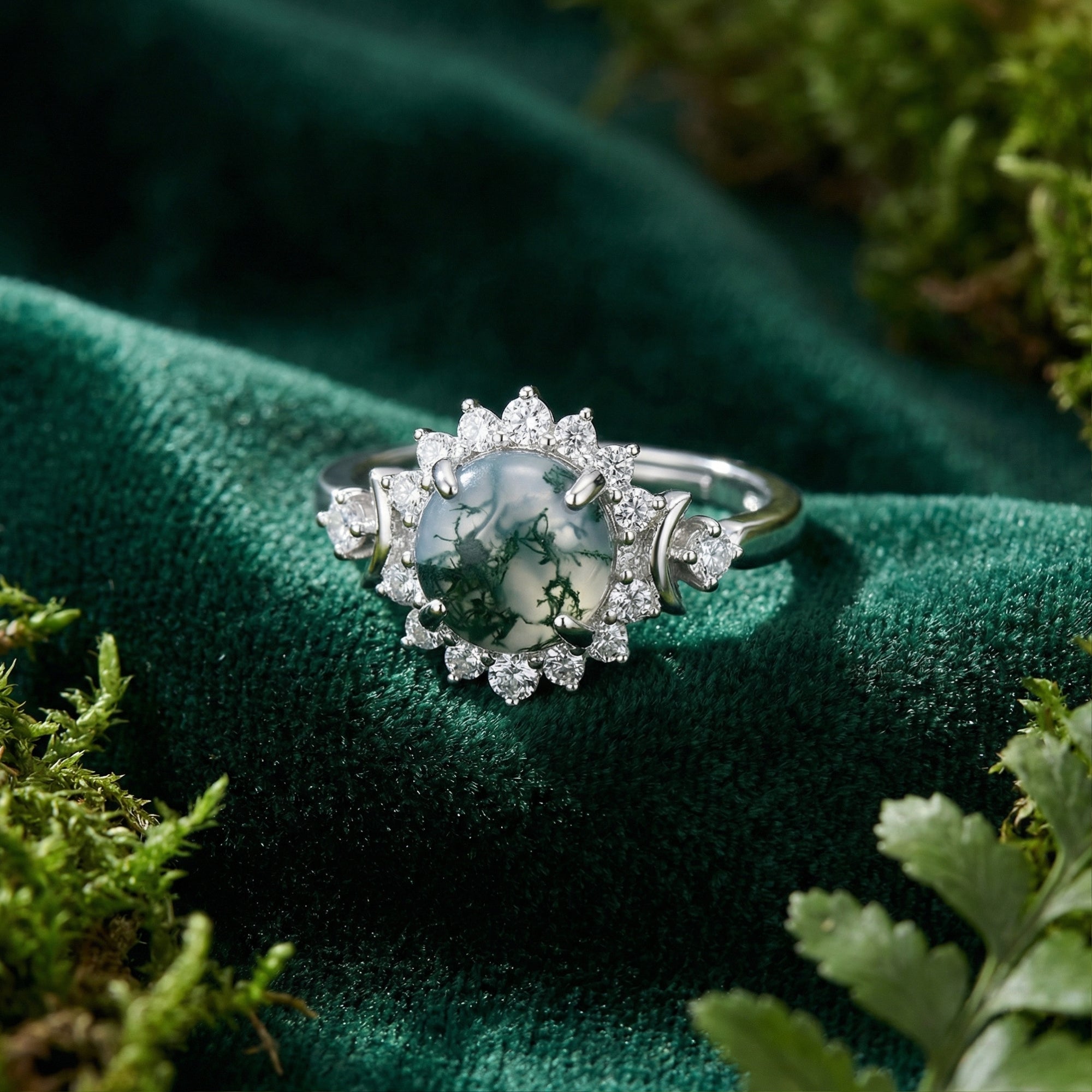 Top-down view of a round natural moss agate floral halo ring in S925 sterling silver on a green velvet background.