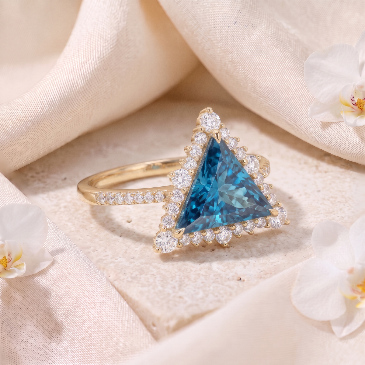 Angled perspective view of a yellow gold trillion-cut blue moissanite halo ring