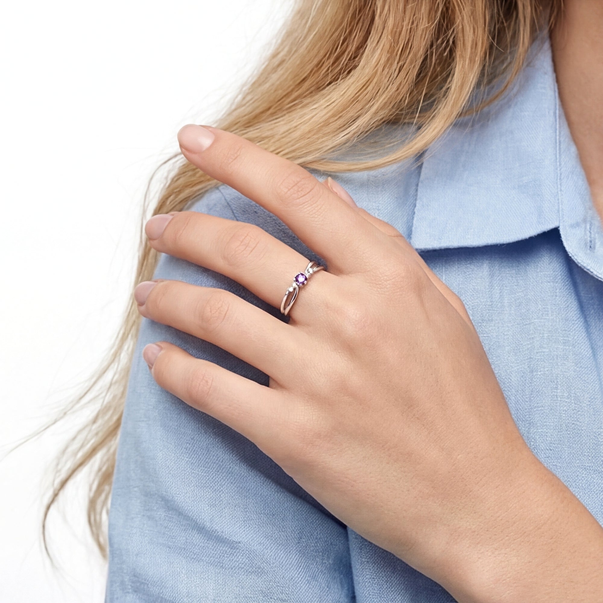 Woman wearing the Astraea sterling silver ring with a round purple amethyst on her finger.