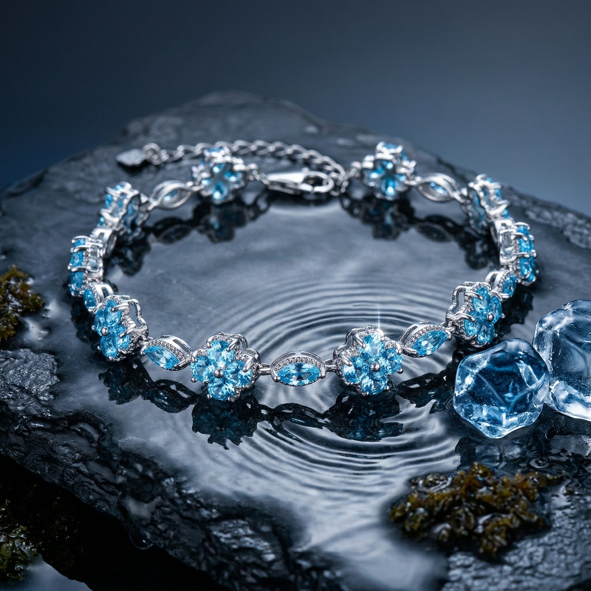 Sterling silver aquamarine station bracelet with marquise and cluster stones on a rippled water surface.