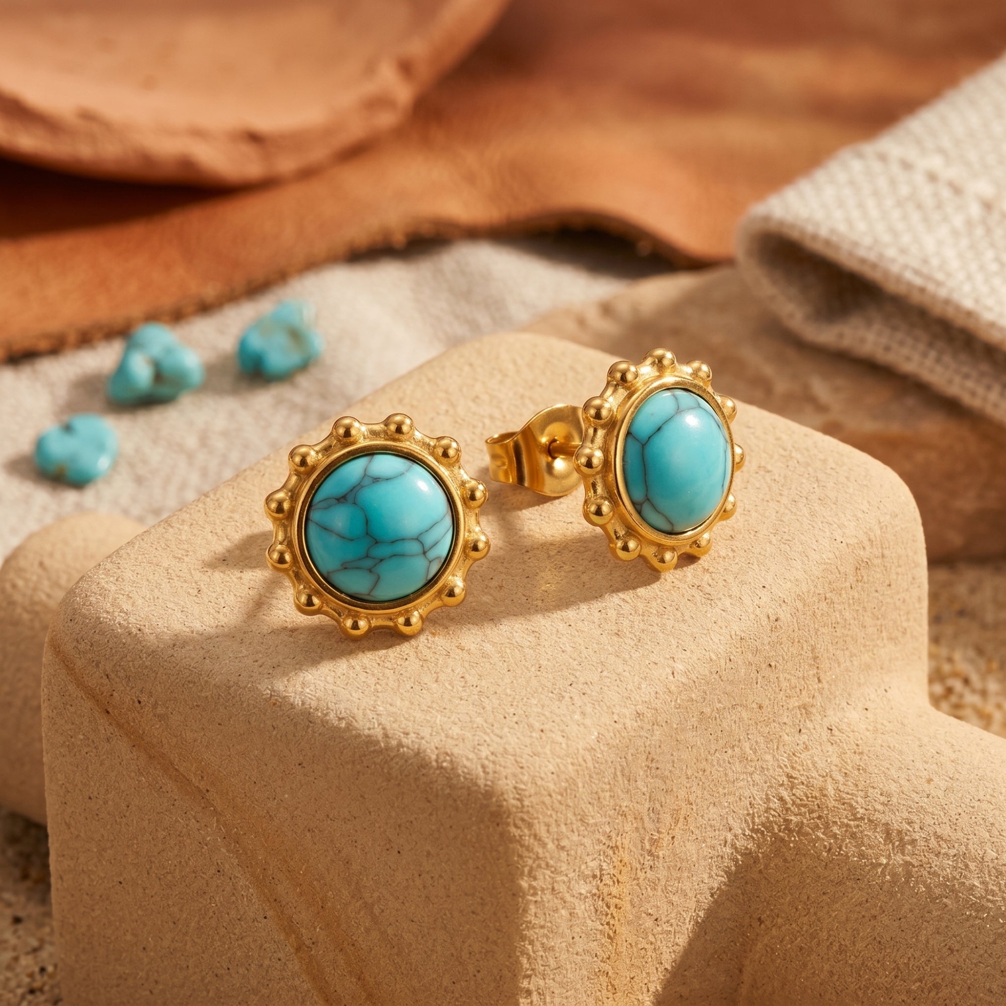 Close-up of gold turquoise cabochon stud earrings showing the intricate dotted bezel and secure post back.