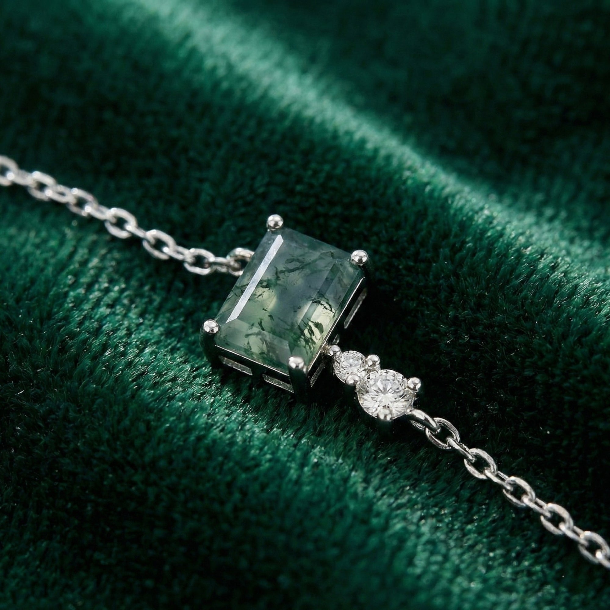 Close-up of a rectangular cut natural moss agate stone and cubic zirconia accents on a sterling silver chain.