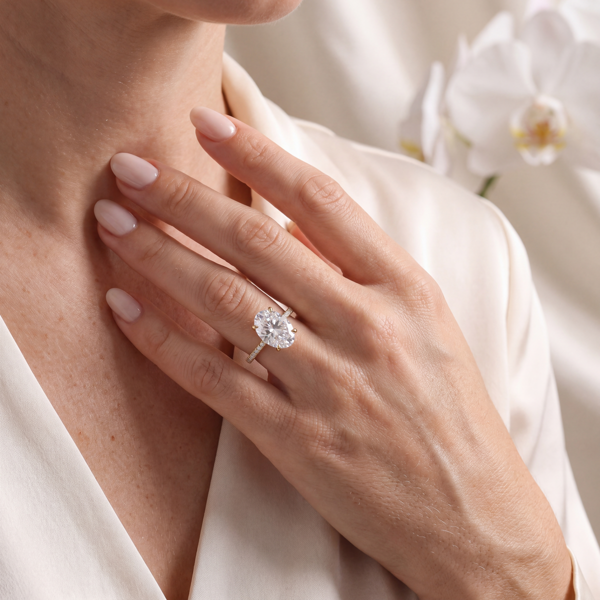 Model wearing the yellow gold oval moissanite pavé engagement ring on her finger.