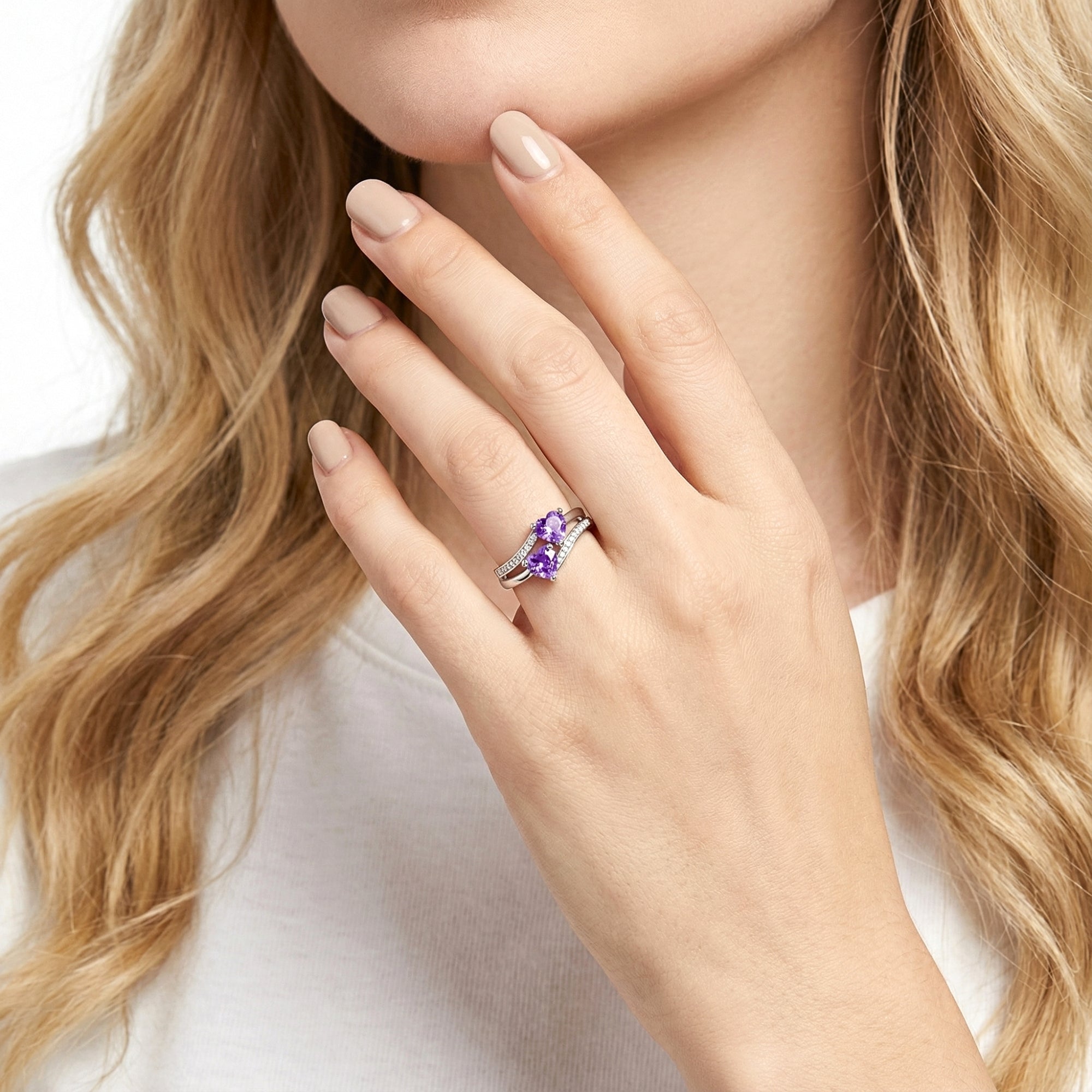 Model wearing the Adara heart ring in S925 sterling silver with purple heart-cut simulated amethysts.