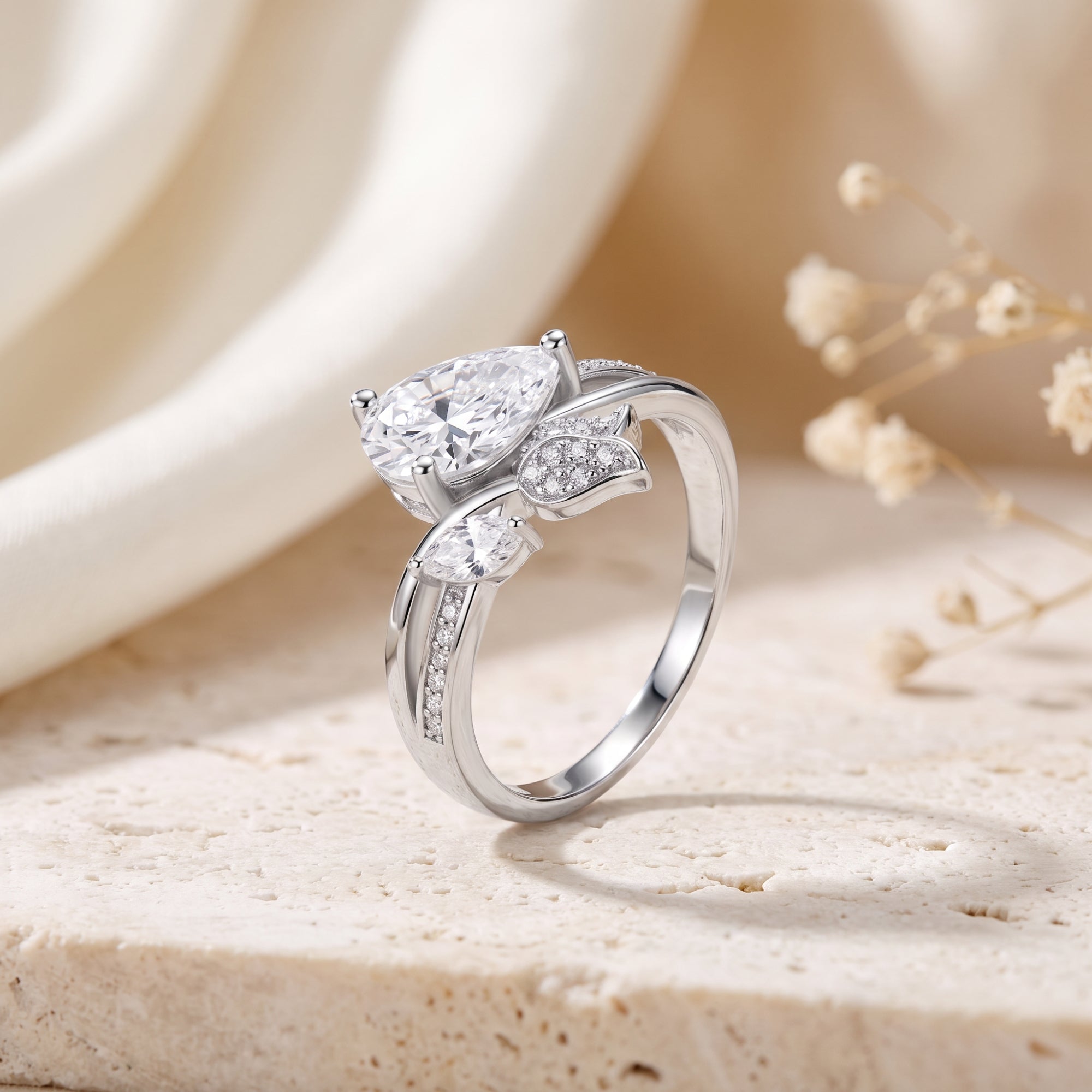 Close-up of the S925 sterling silver bypass leaf vine setting and pear-cut simulated diamond.