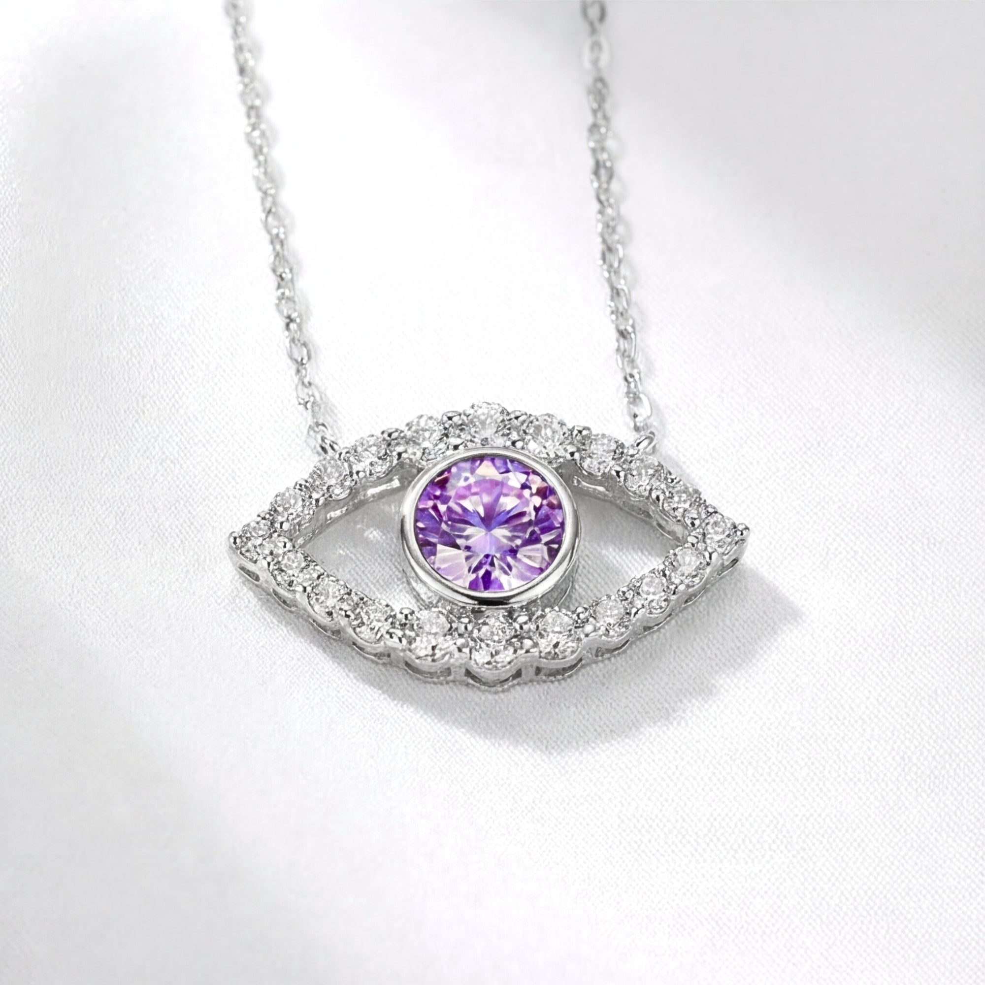 Macro view of the sterling silver evil eye pendant with a round simulated amethyst and moissanite halo.