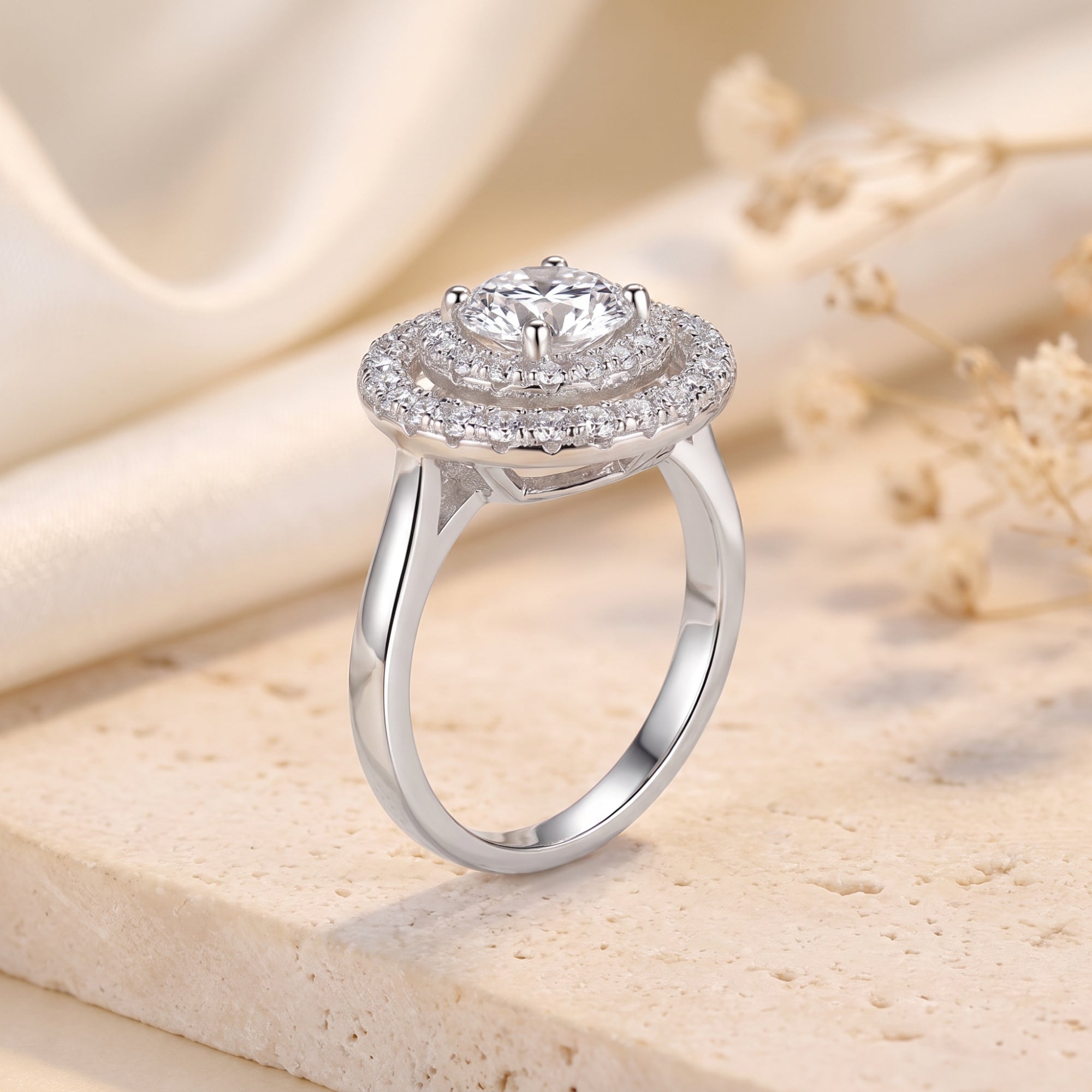 Side view of a silver double halo solitaire ring showing the round stone setting and smooth band.