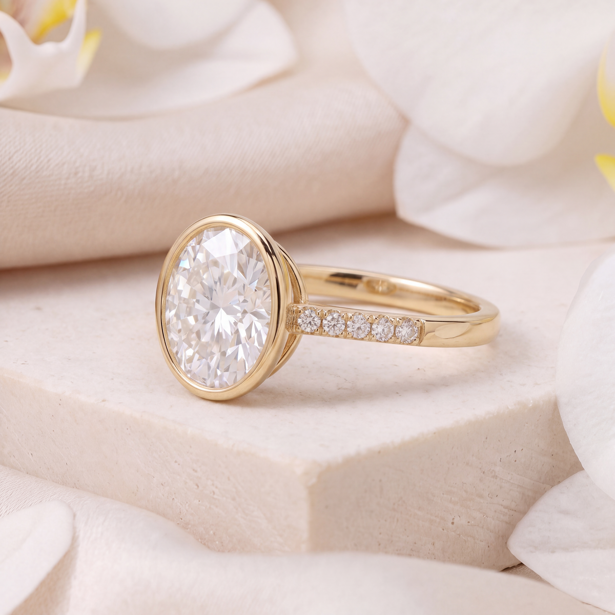 Side view of a yellow gold oval moissanite bezel ring highlighting the pavé accent band.