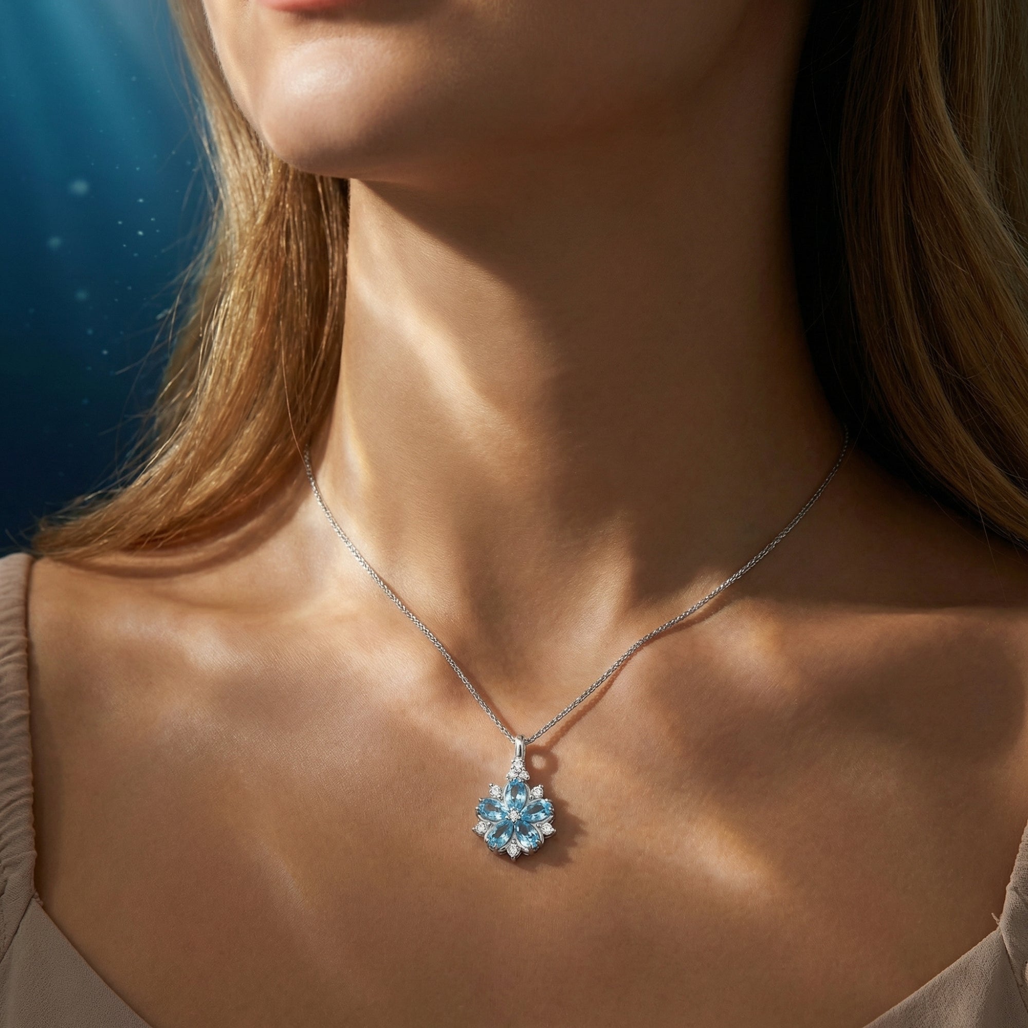 Model wearing the white gold Melita Blossom necklace with marquise cut aquamarine stones in a floral design.