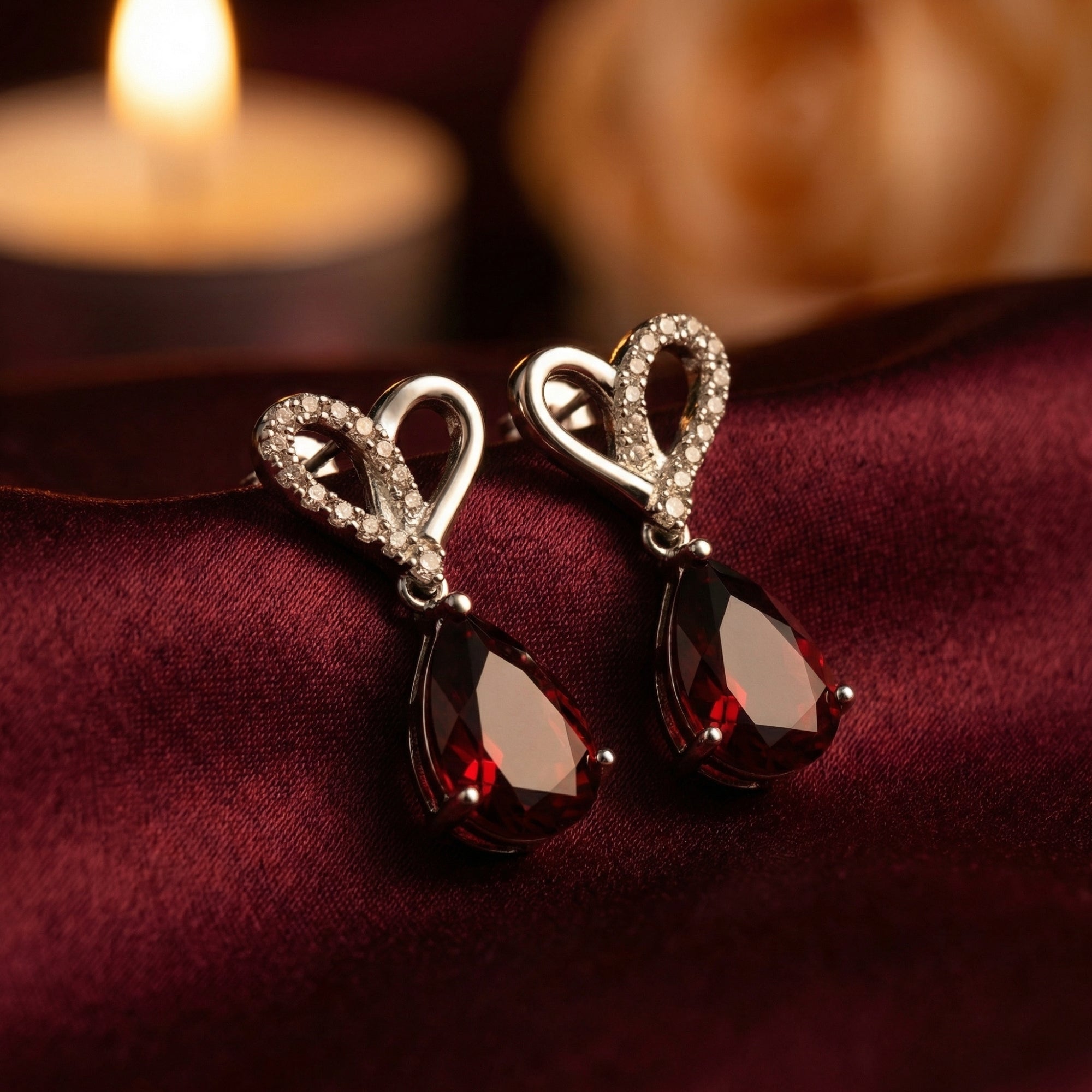 Macro view of Lovisa pear-cut garnet drop earrings in white gold showing the detailed heart-shaped pavé setting.