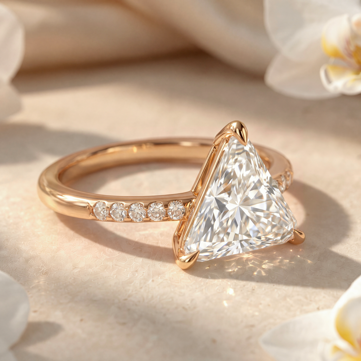 Close-up side view of a gold trillion-cut moissanite engagement ring showing setting details.