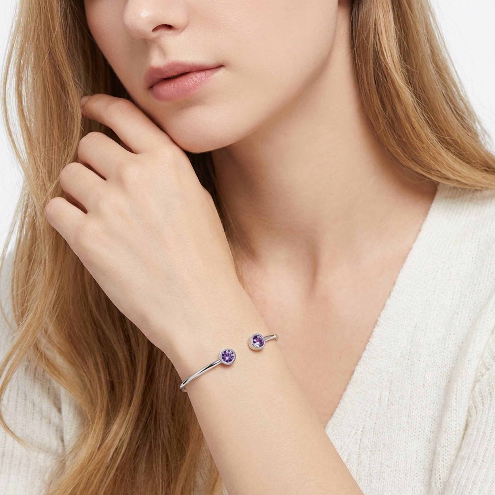 Silver stainless steel Liora open-cuff bracelet with round purple amethyst stones on a woman's wrist.