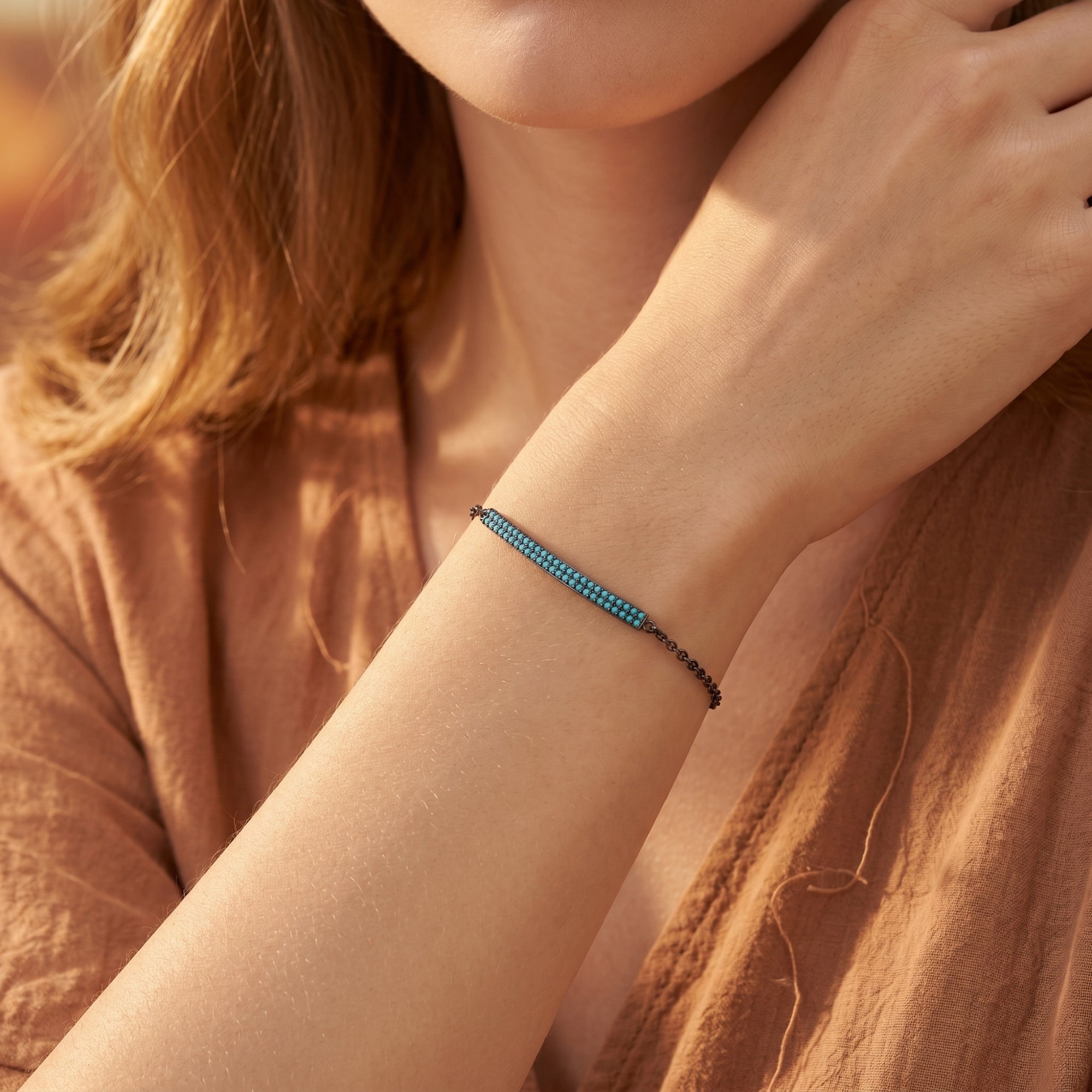 Close-up of the Escalante turquoise bar bracelet in sterling silver on a model's wrist, showing the delicate chain.