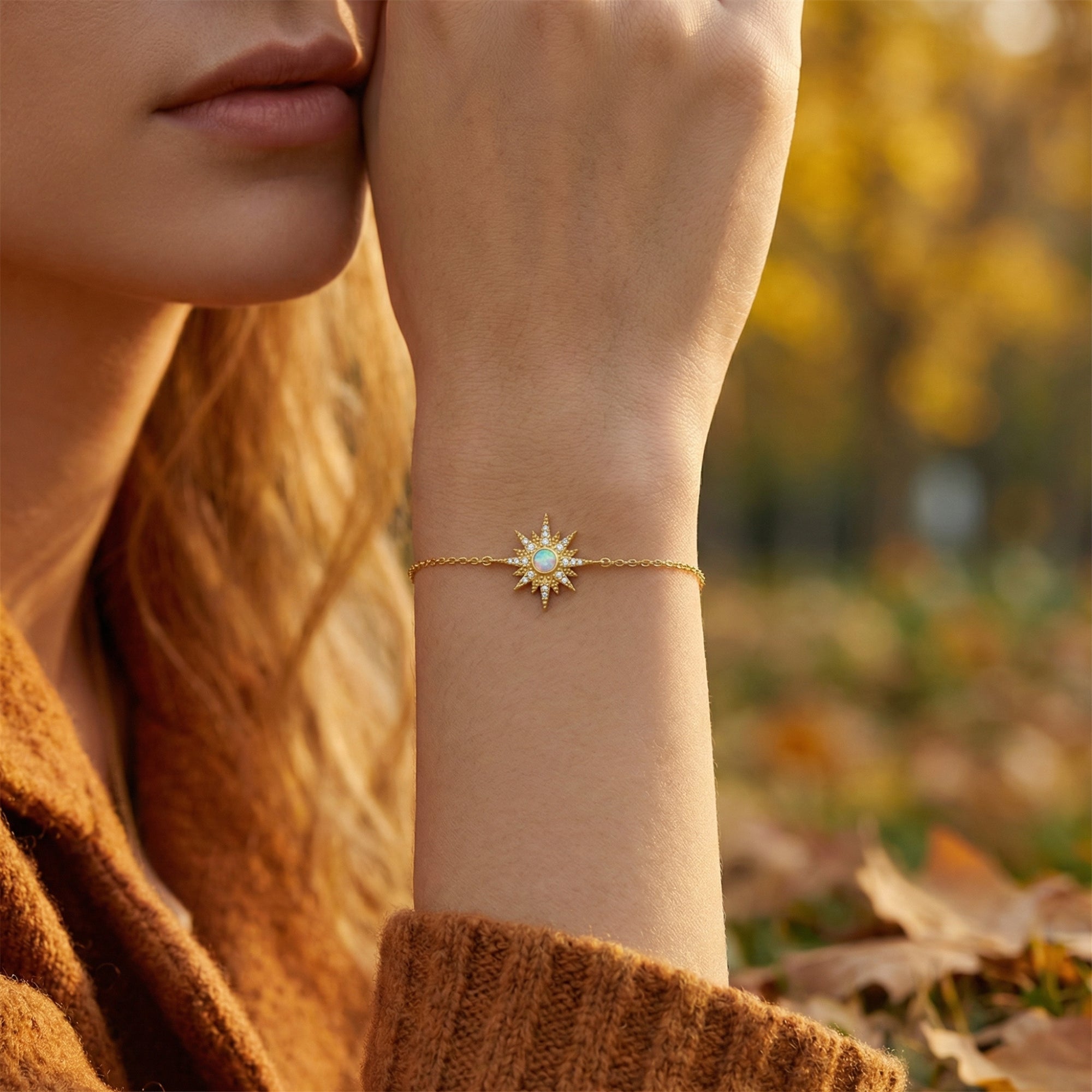 Close-up of the gold-tone sterling silver Elowen starburst bracelet with a round-cut opal on a wrist.