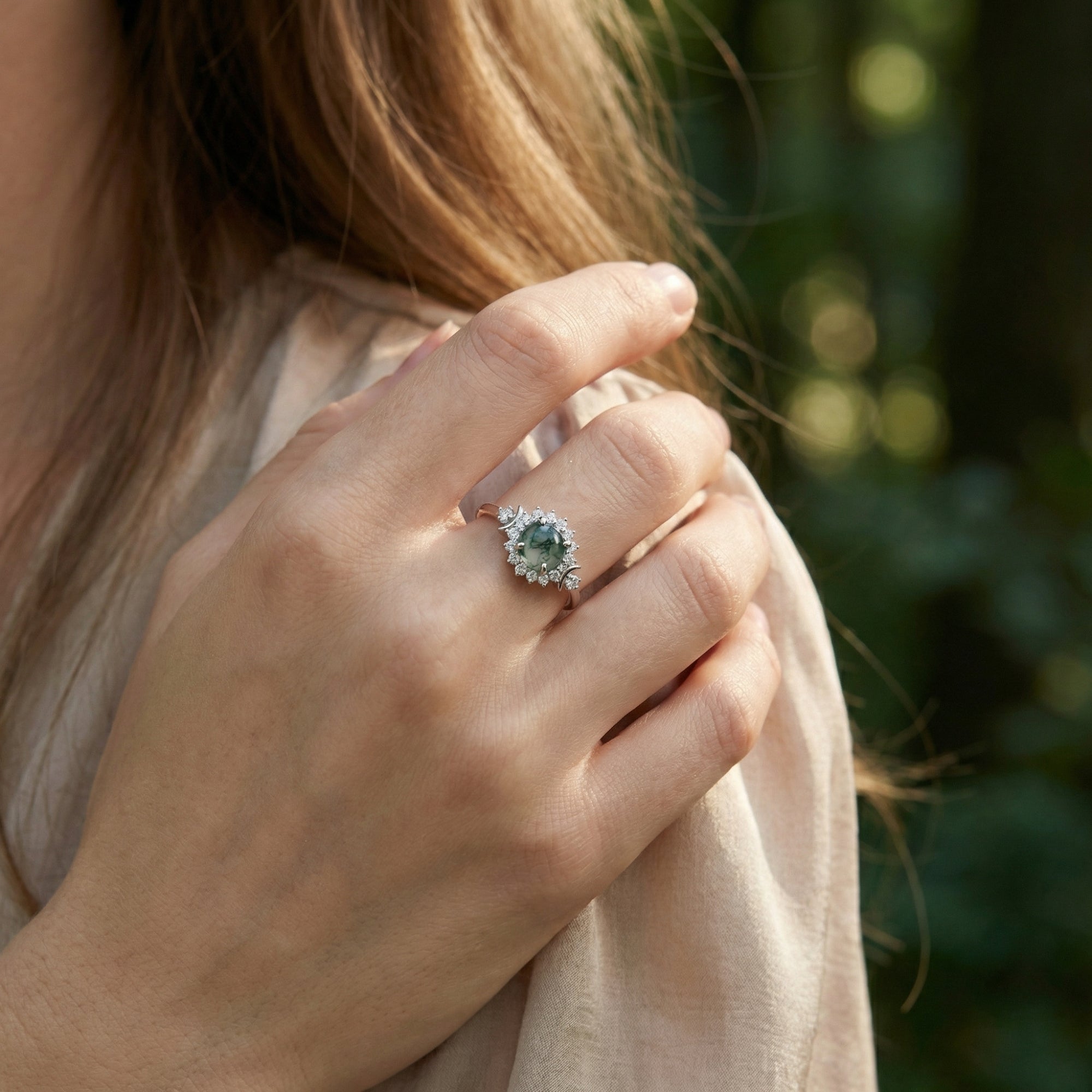 Woman wearing a round natural moss agate floral halo ring in S925 sterling silver against a soft background.
