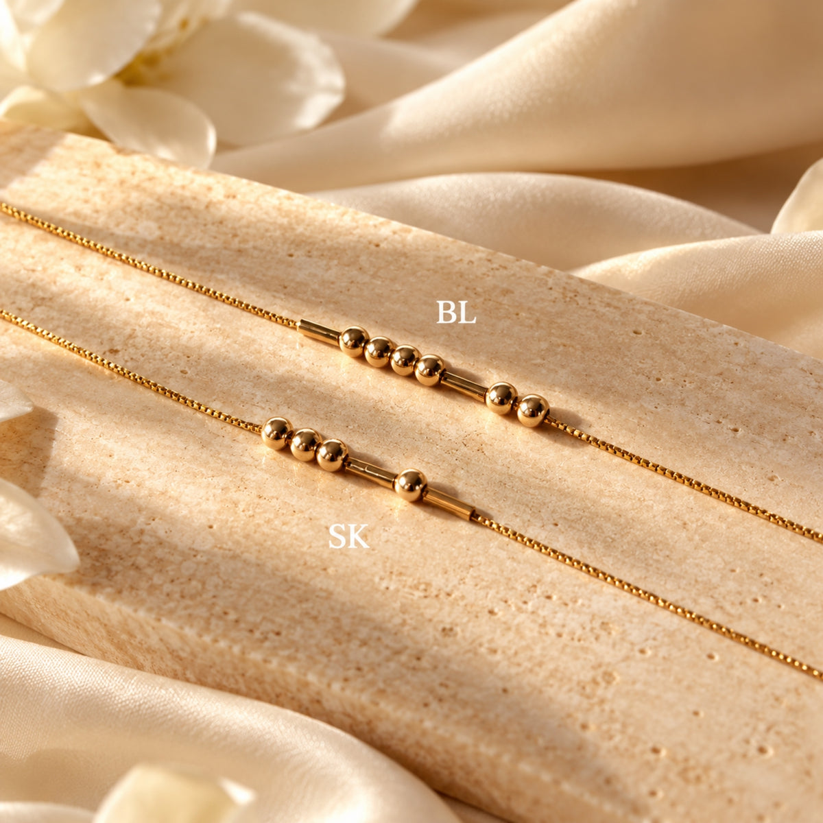 Two Gold-finish Morse-code bracelets on a stone display, with BL and SK example labels.